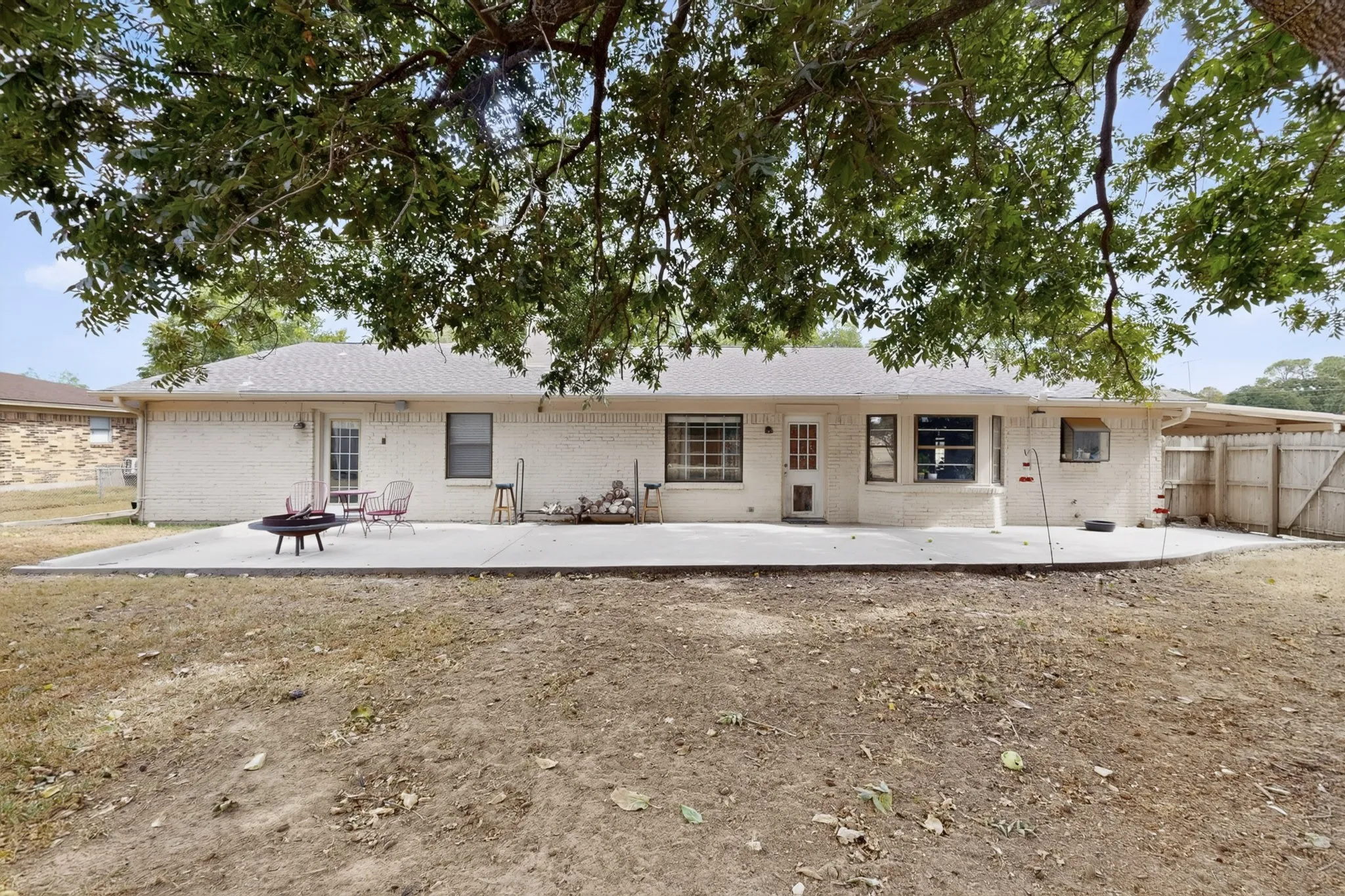 Old growth trees shade the large backyard space, which features a lovely extended patio area behind the home.