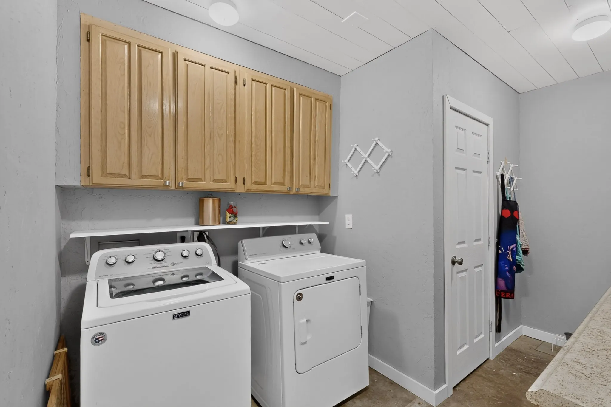 Dedicated laundry room features built in storage and folding table, located just off the mudroom and carport.