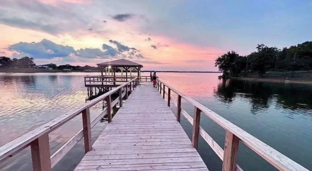 Expansive wood dock leading to a covered gazebo over water