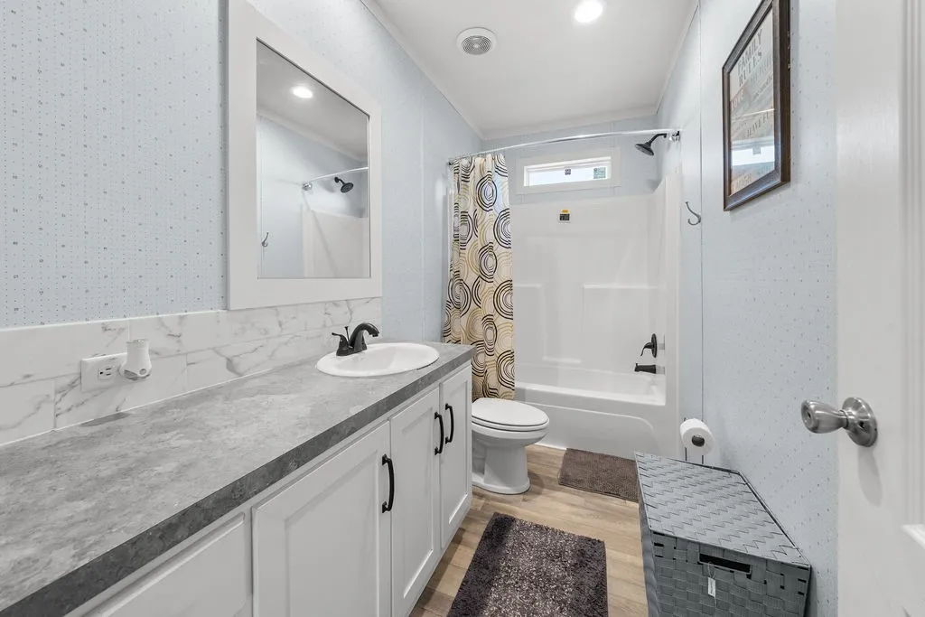 White vanity with dark hardware, a white vessel sink, and a gray countertop