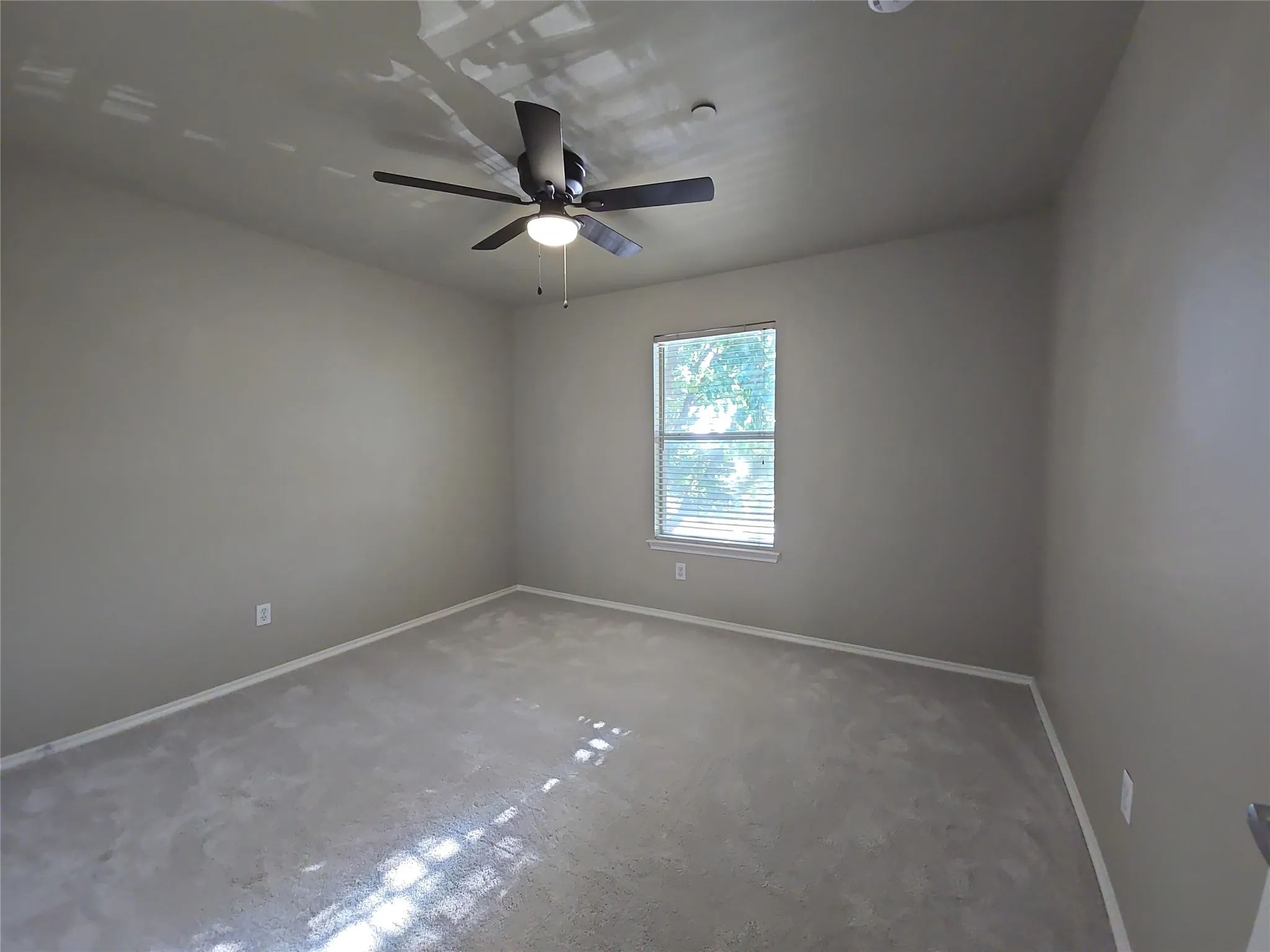 Recessed window with blinds, ceiling-mounted fan with integrated light, and neutral wall paint