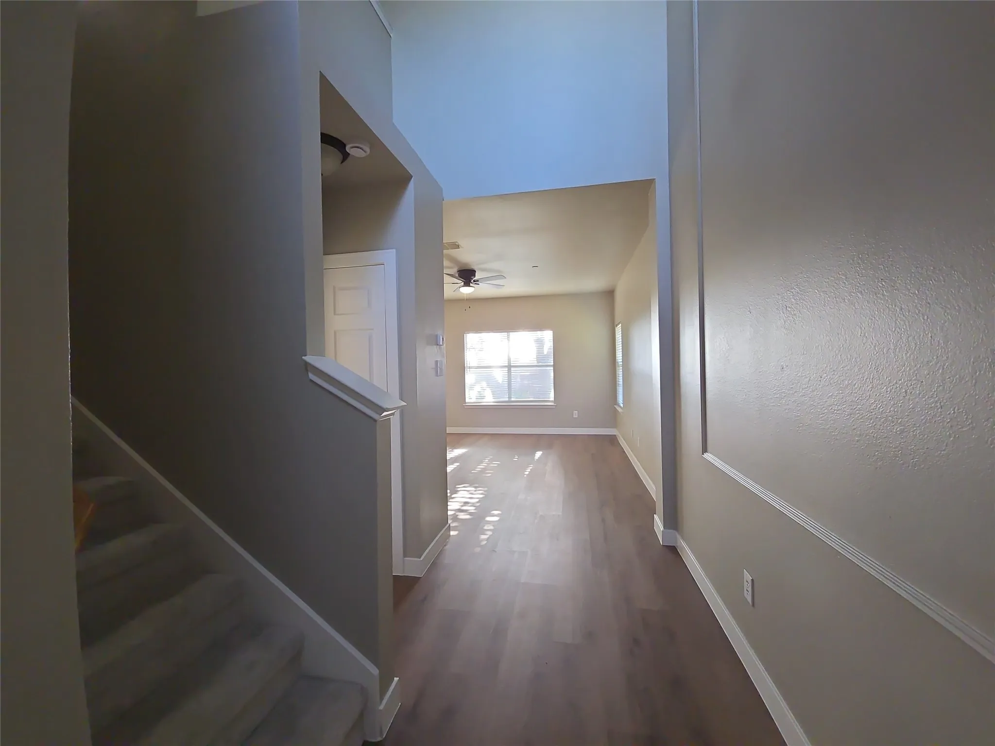 Vaulted ceilings, wood-finish flooring, carpeted staircase, ceiling fan, and recessed lighting