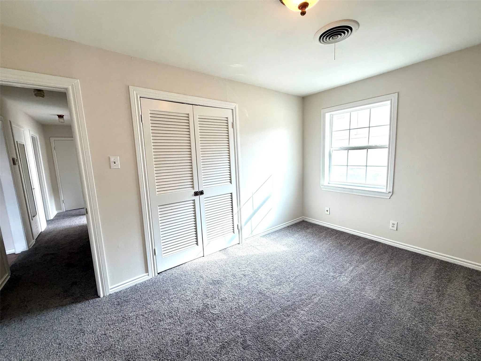 Neutral-toned walls complement the gray carpeting