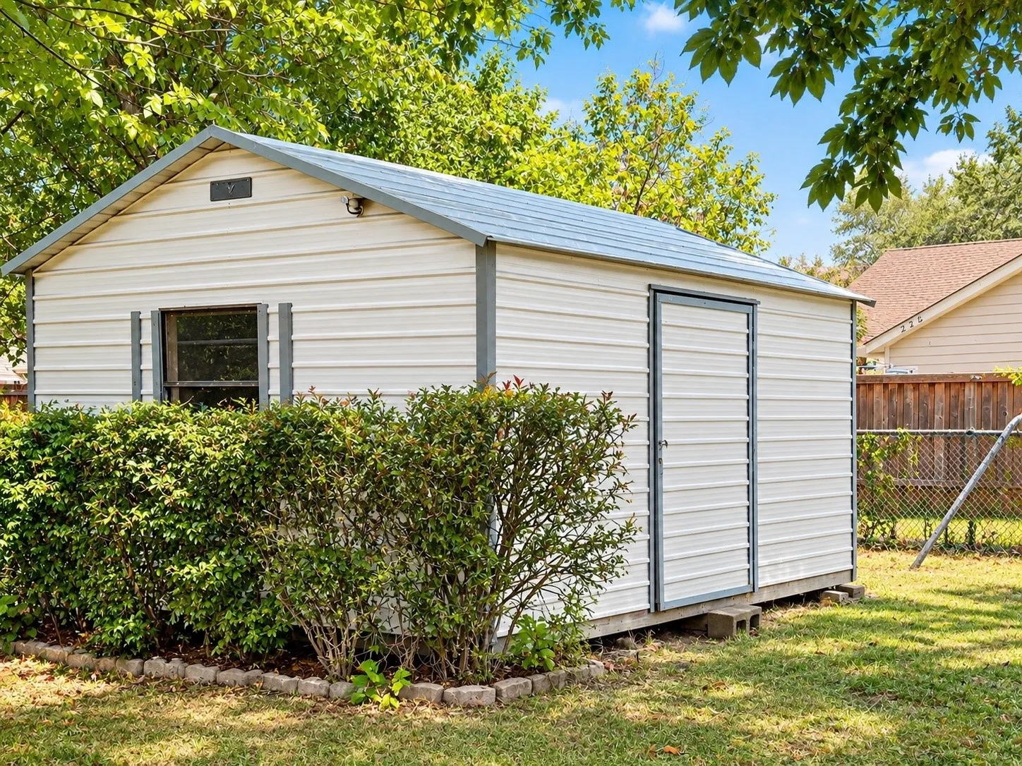 Workshop featuring white siding, a gray metal roof, and a single entry door