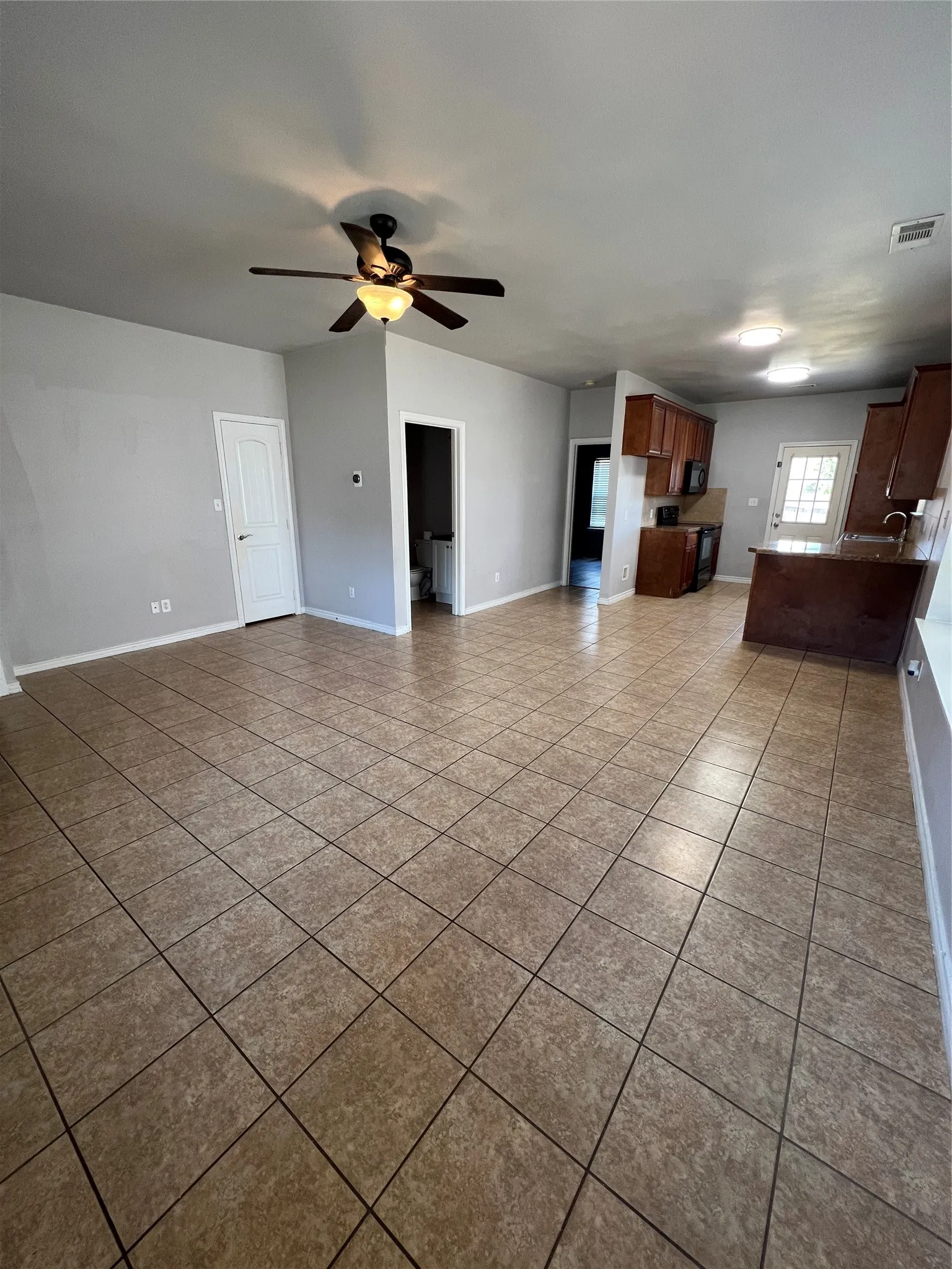 Open-concept living space featuring ceramic tile flooring, a ceiling fan with integrated lighting, and recessed ceiling lighting