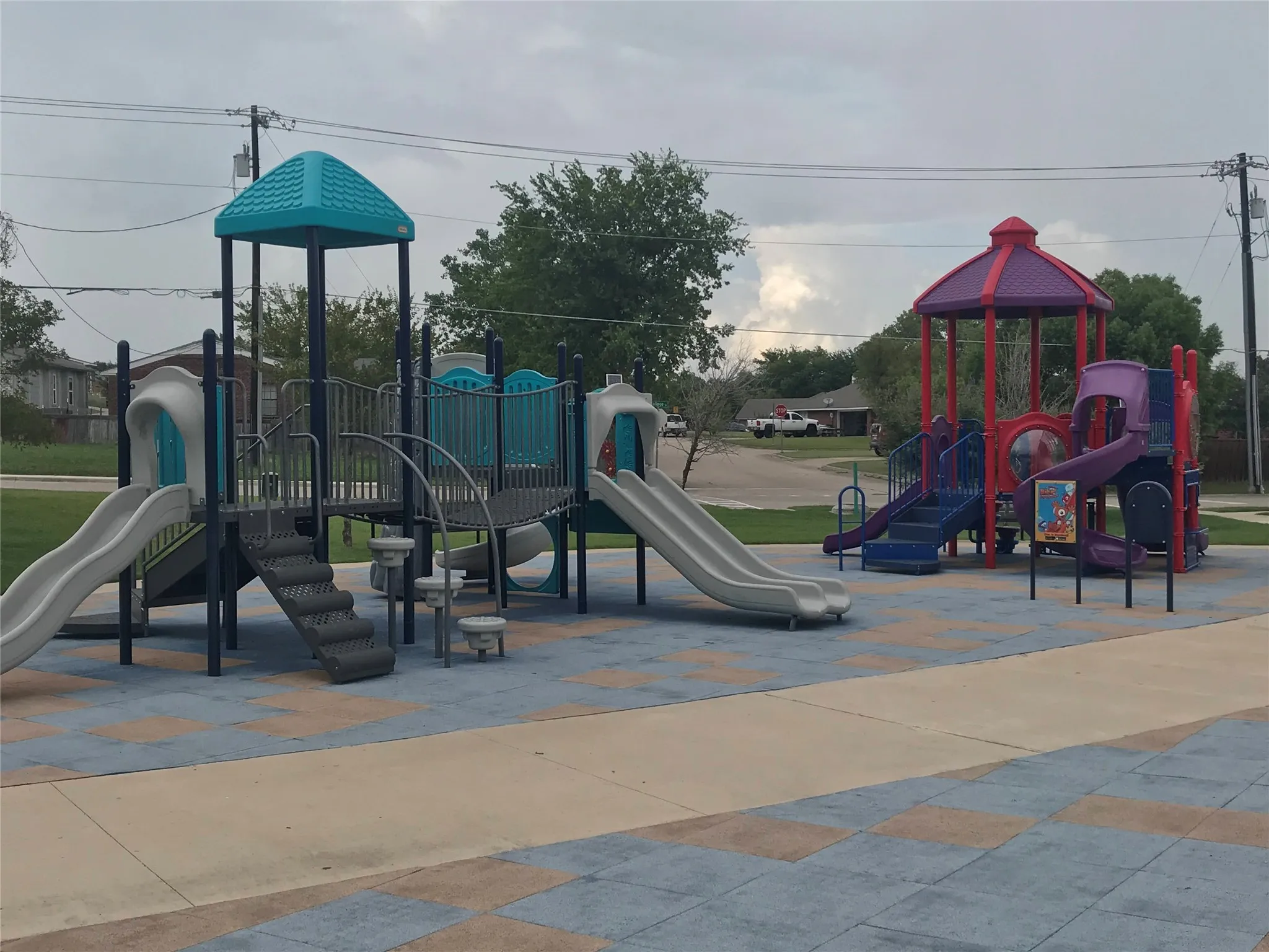Playground structure featuring multiple slides, climbing elements, and a covered platform