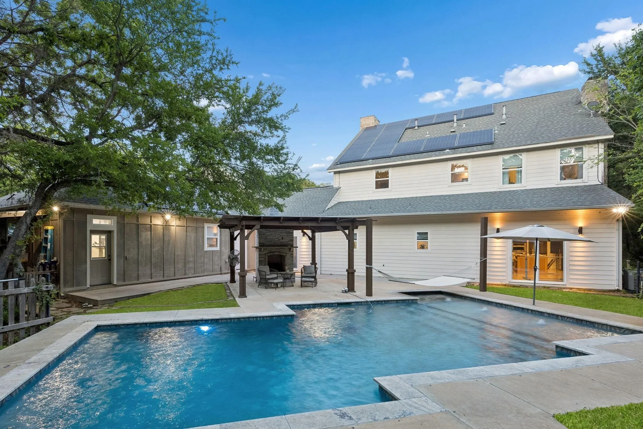 Resort-style backyard featuring a sparkling pool surrounded by mature trees for exceptional privacy.