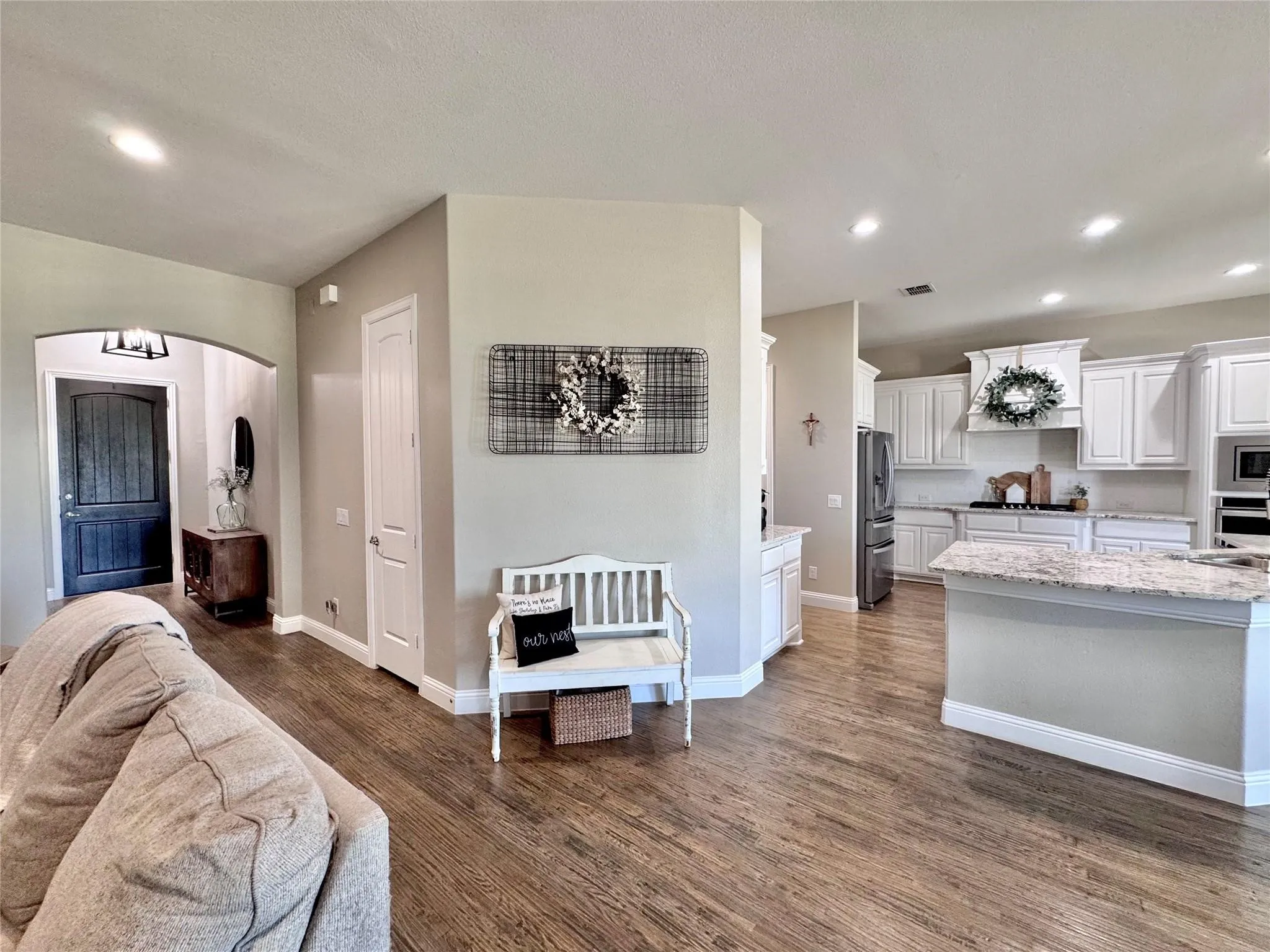 Distressed hardwood flooring throughout the entry, living room, kitchen into the primary bedroom!
