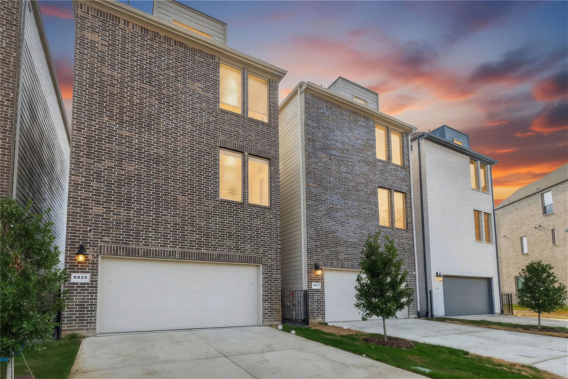 Brick exterior with a multi-level design, attached garage, and a concrete driveway