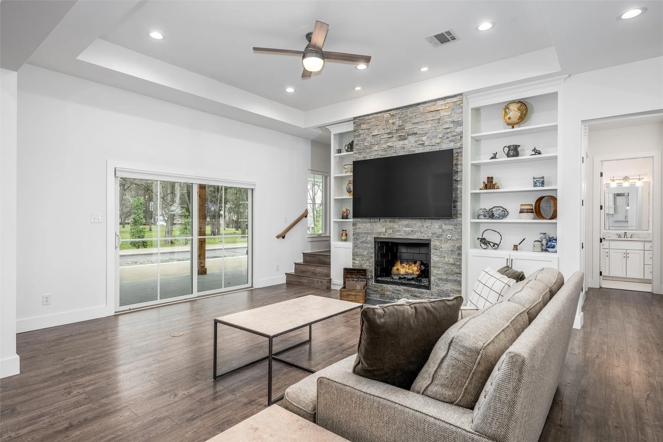 Inviting living room with fireplace and built in shelving.