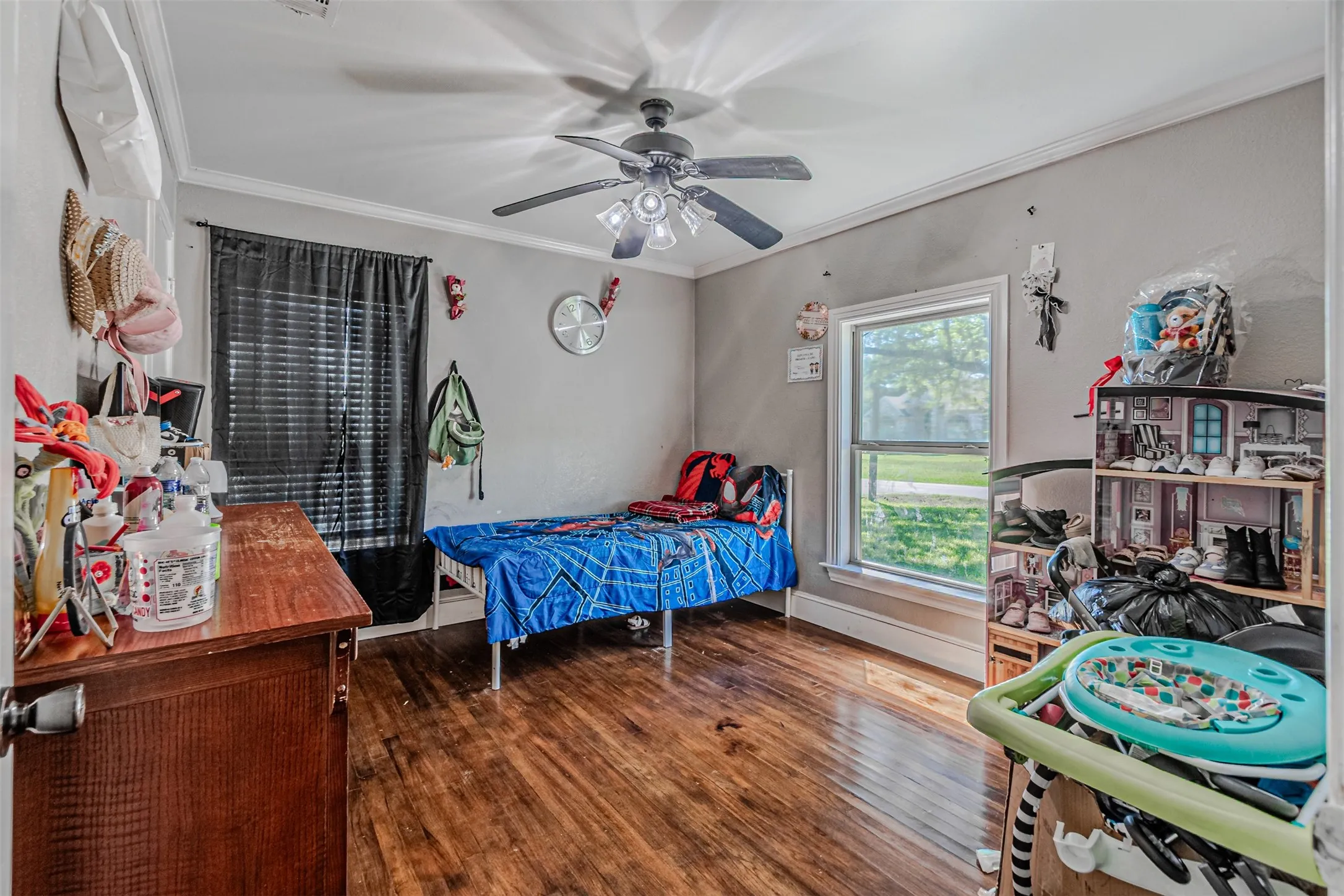Hardwood-style flooring, white trim, and a ceiling fan with integrated lighting