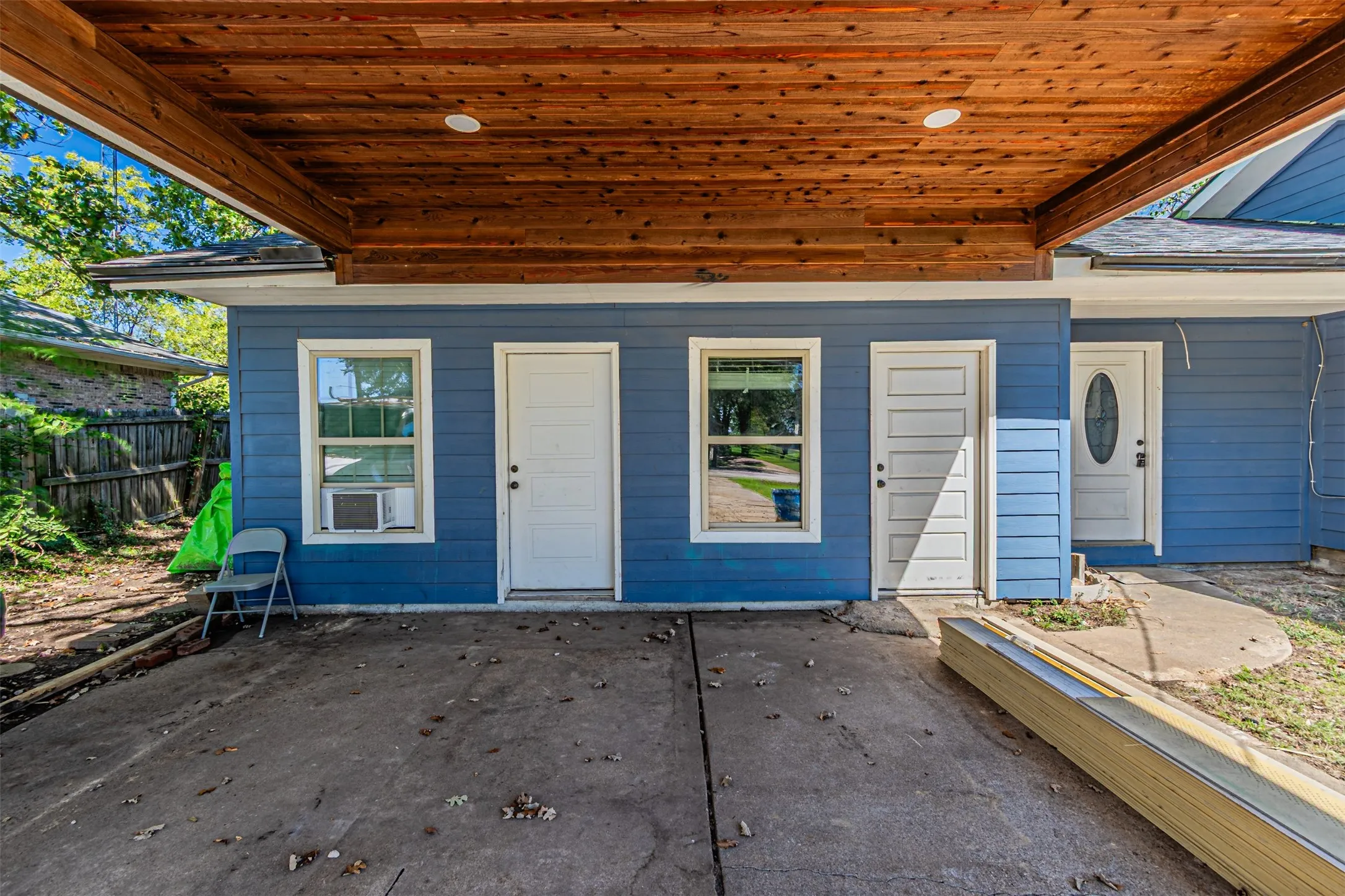 Blue siding exterior with a wood-finish ceiling carport featuring recessed lighting
