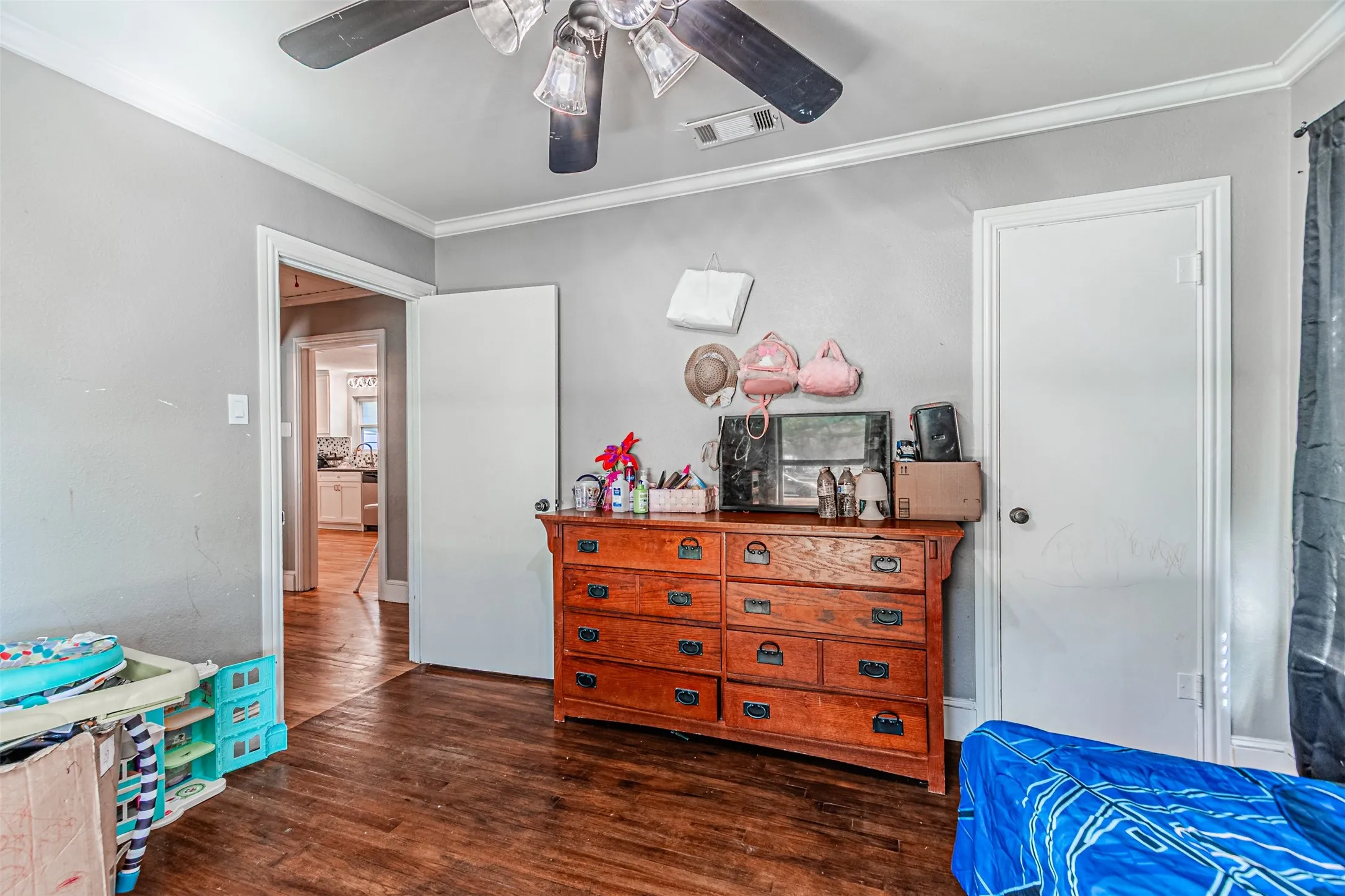 Wood-finish flooring with white trim and crown molding