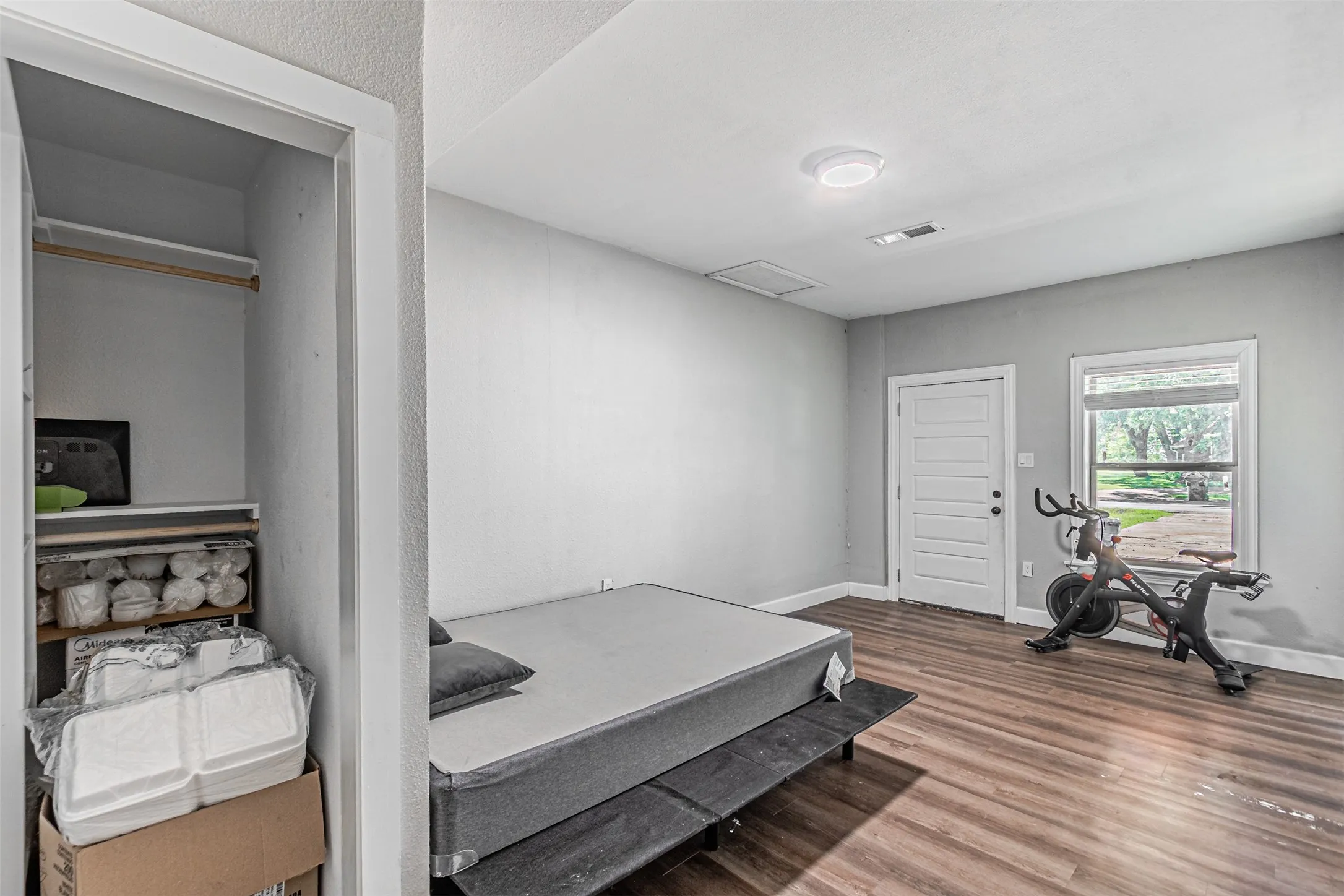 Room featuring wood-finish flooring, a paneled door, and an overhead light fixture