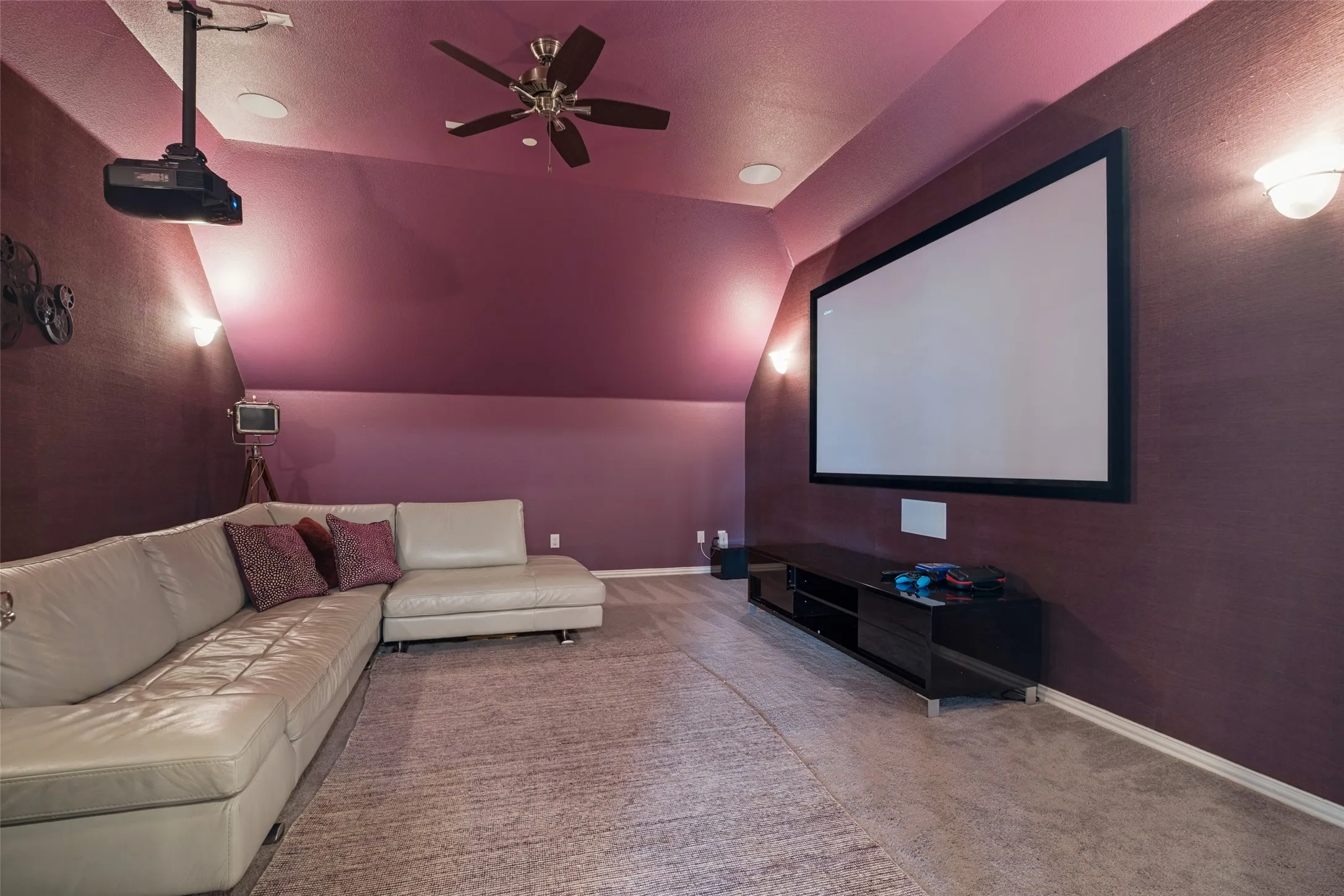 Ceiling-mounted projector, wall-mounted screen, built-in ceiling fan, recessed lighting, and wall sconces