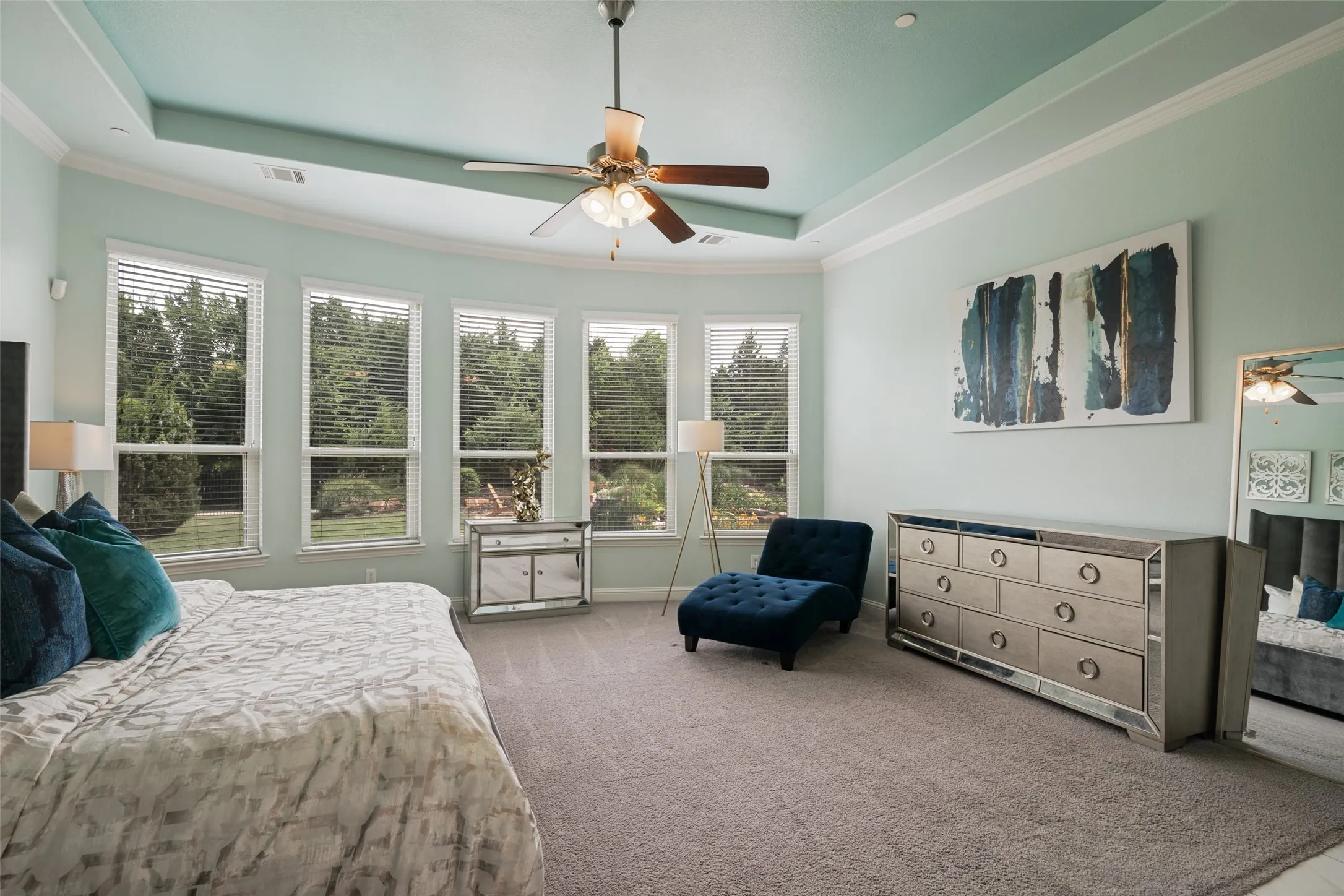 Tray ceiling with crown molding, ceiling fan, and recessed lighting