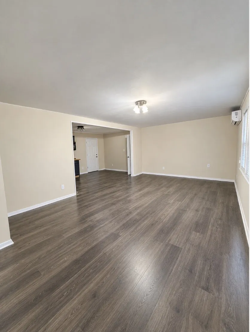 Wood-finish flooring, neutral wall tones, and overhead lighting