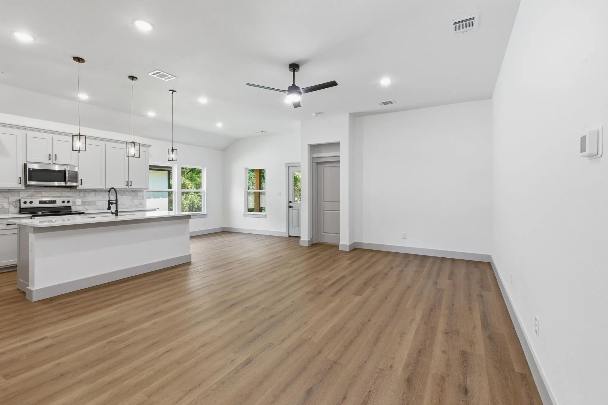 Kitchen with white cabinetry, stainless steel appliances, and a central island with bar seating