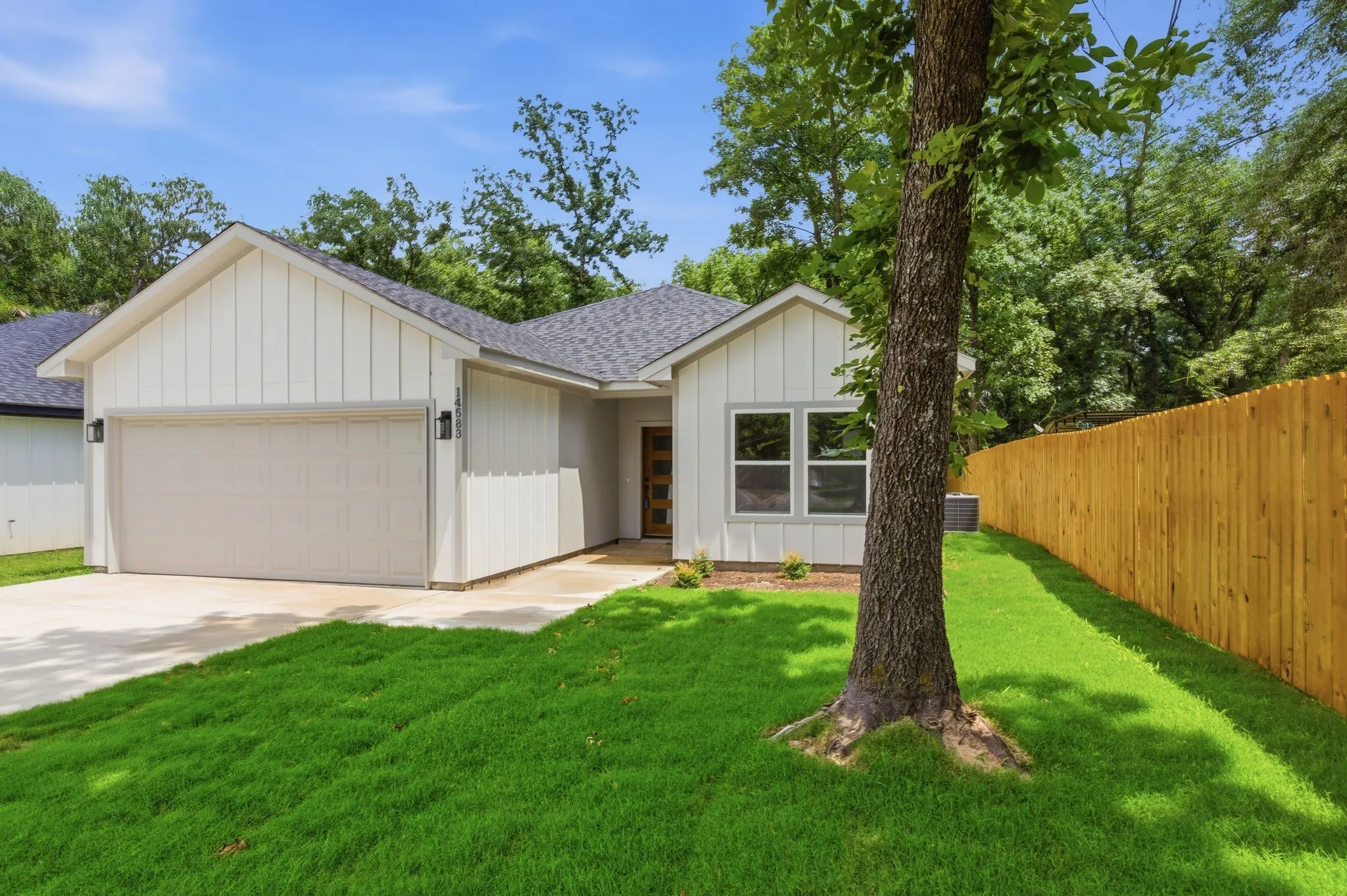 Contemporary exterior featuring vertical siding, a two-car garage, and a charcoal-toned shingle roof