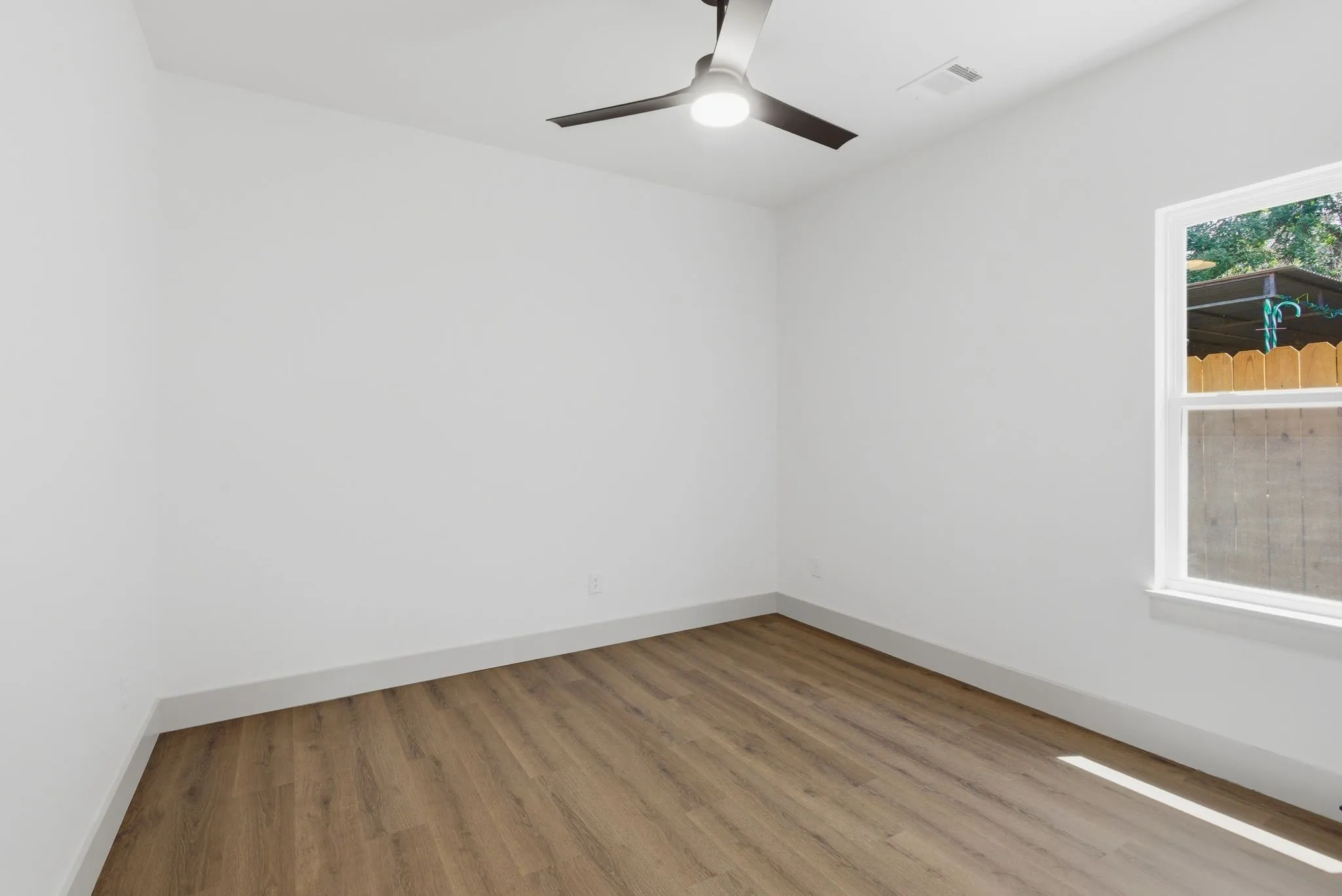 Recessed lighting, wood-finish flooring, and a contemporary ceiling fan