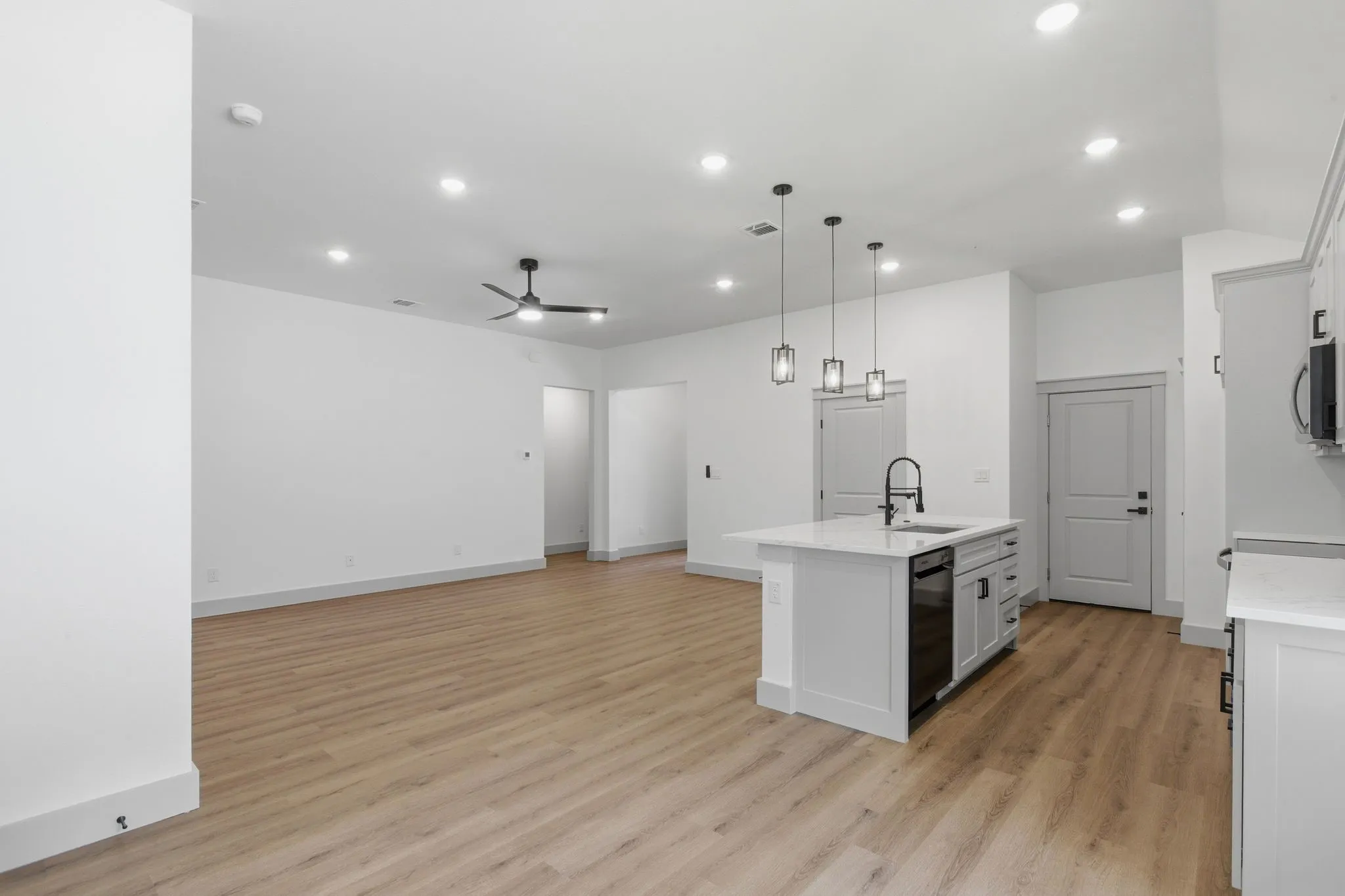 Open-concept living space featuring wood-finish flooring, recessed lighting, and a ceiling fan