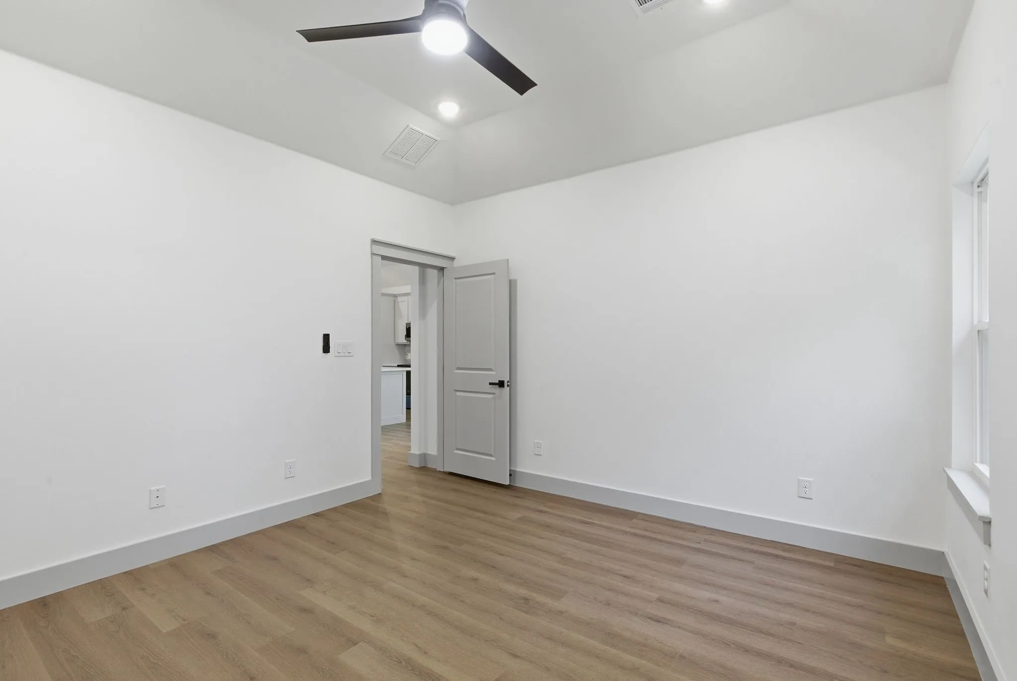 Wood-finish flooring, recessed lighting, and a contemporary ceiling fan