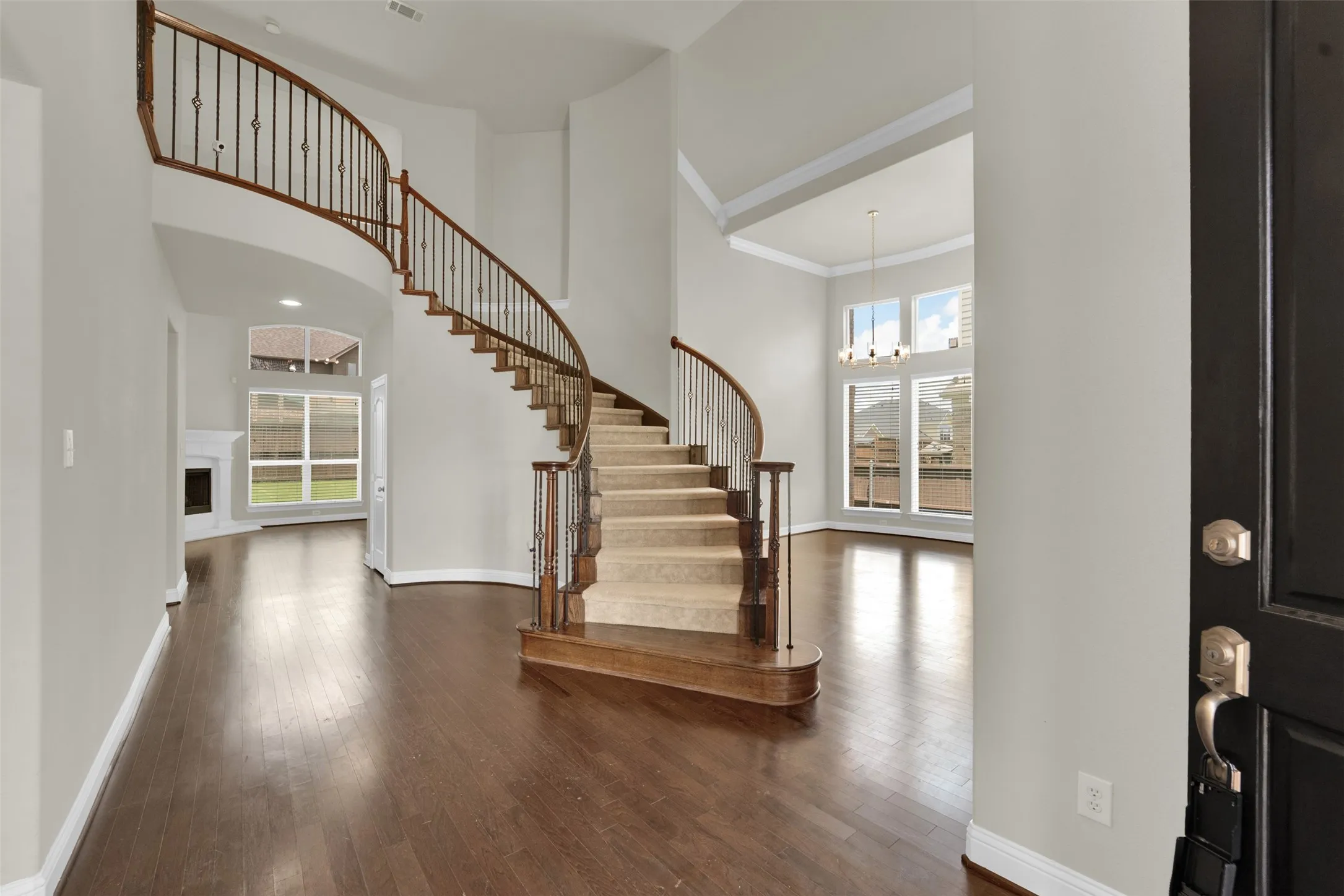 Grand foyer featuring a curved staircase with wrought iron balusters and wood handrails