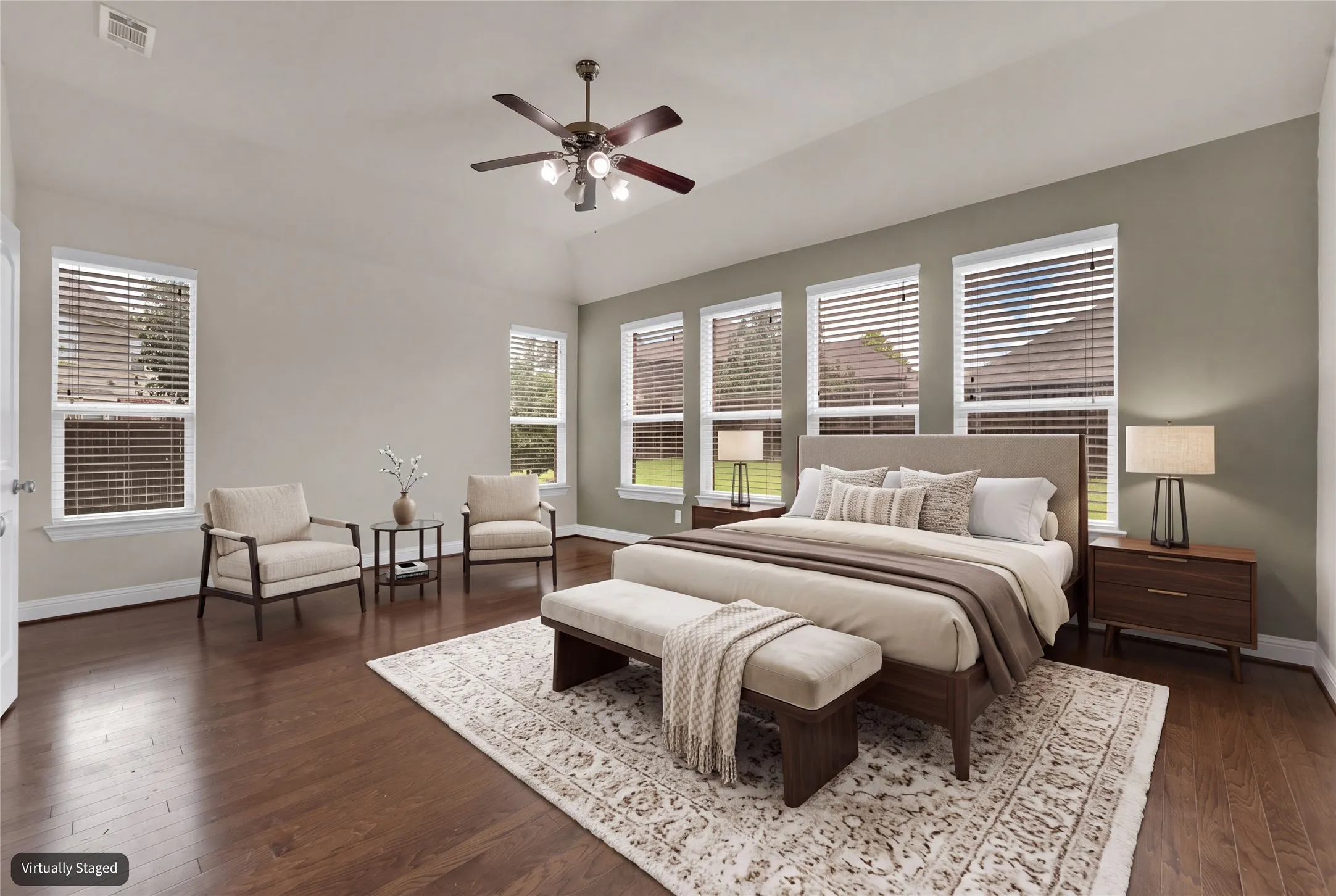 Vaulted ceiling with ceiling fan, wood-finish flooring, multiple windows with blinds, and neutral wall tones