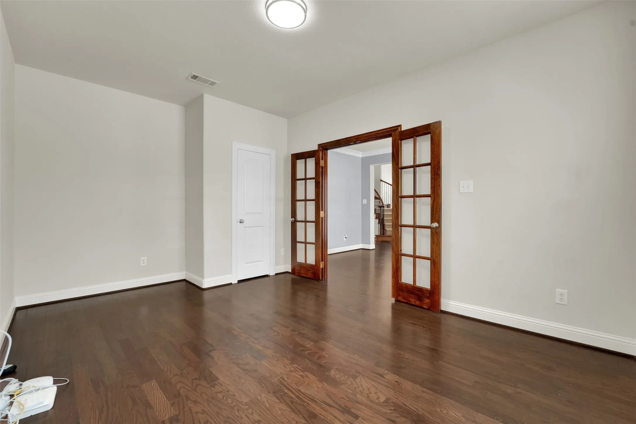 Hardwood flooring, white baseboards, and neutral wall paint