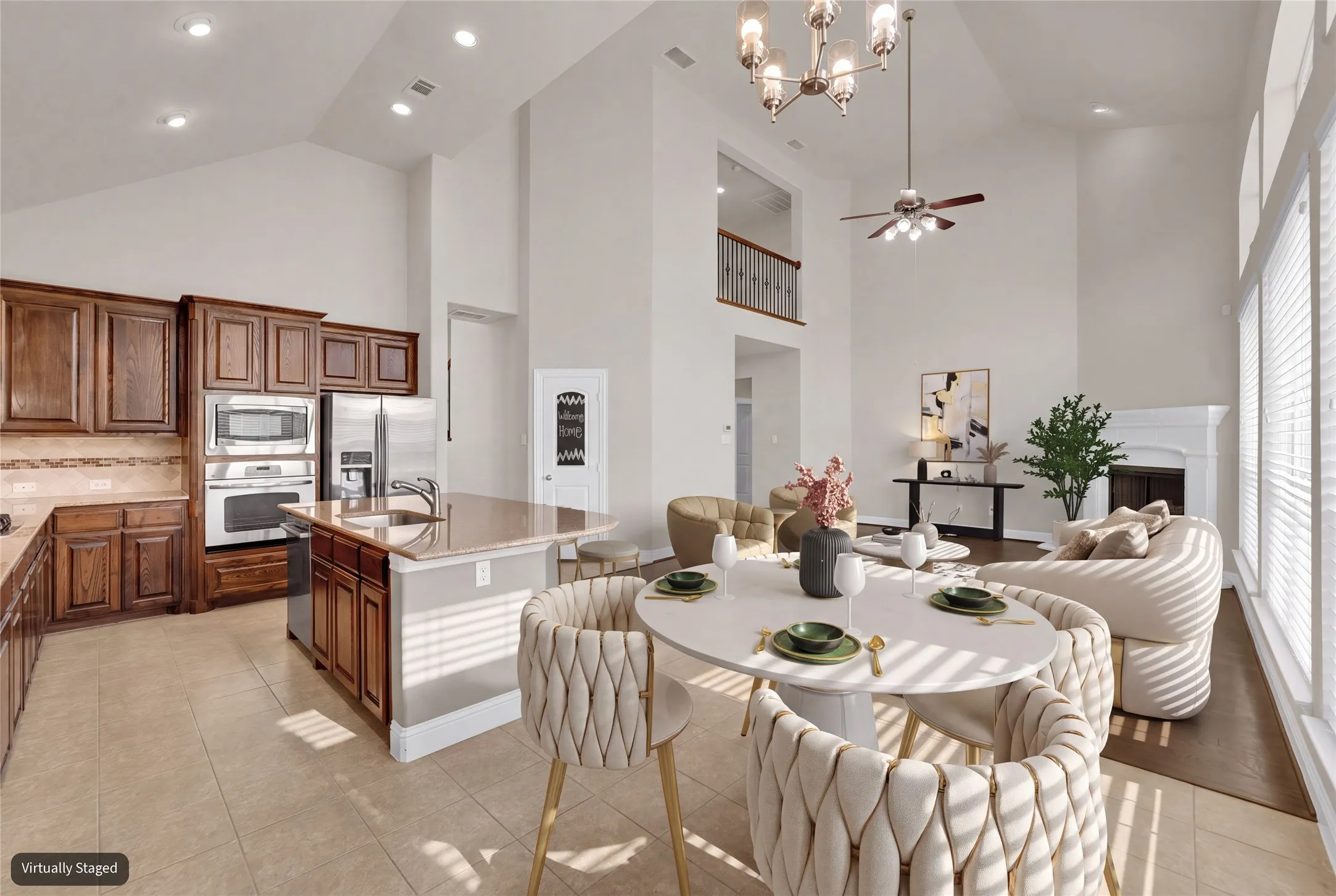 Spacious open-concept interior featuring a kitchen island with a built-in sink, stainless steel appliances, and wood cabinetry