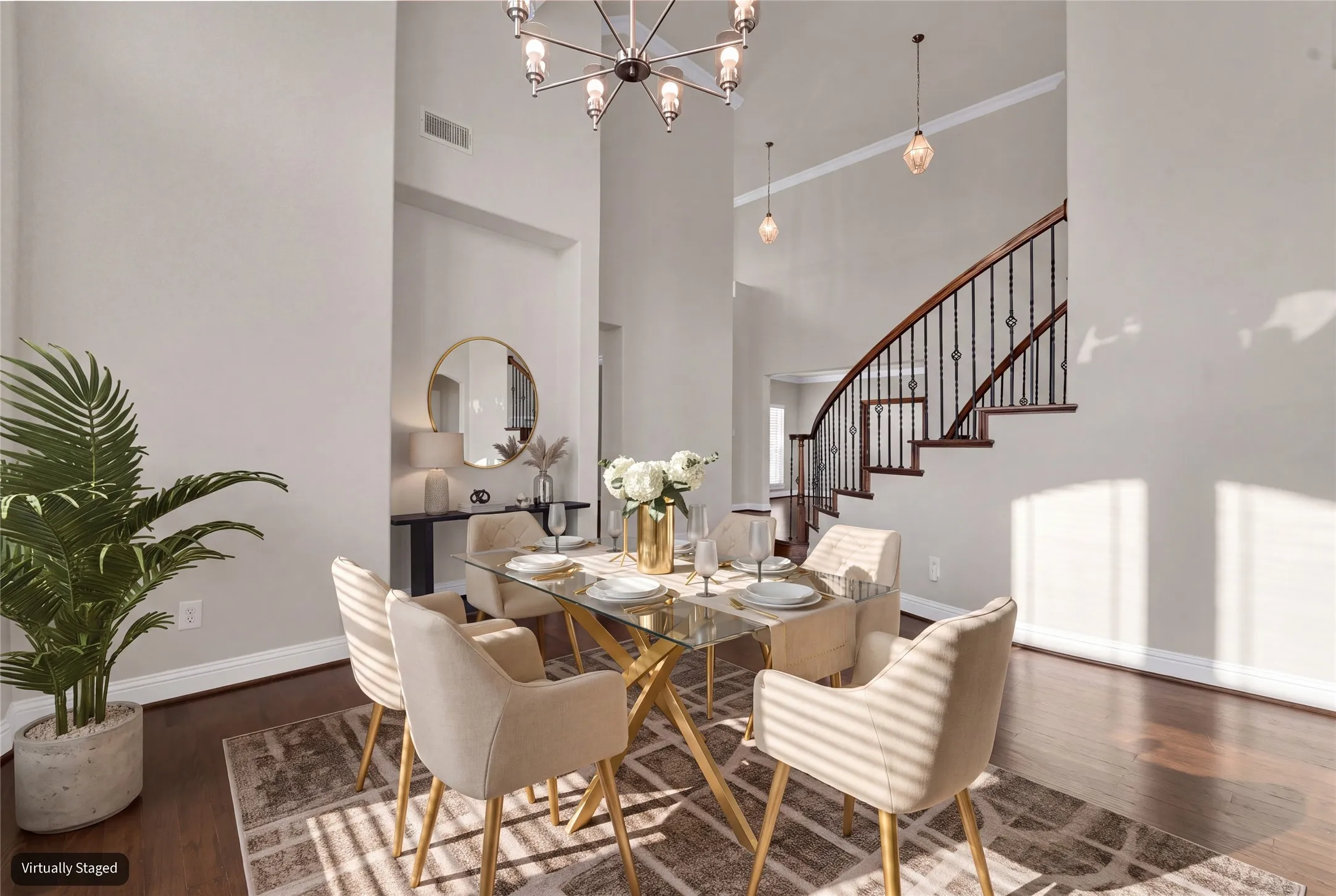 Hardwood flooring and high ceilings complement the curved staircase with iron balusters