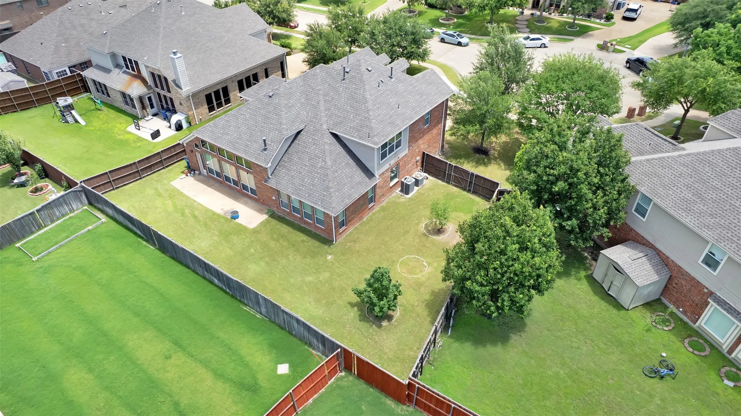 Brick exterior with a gray shingle roof and multiple windows