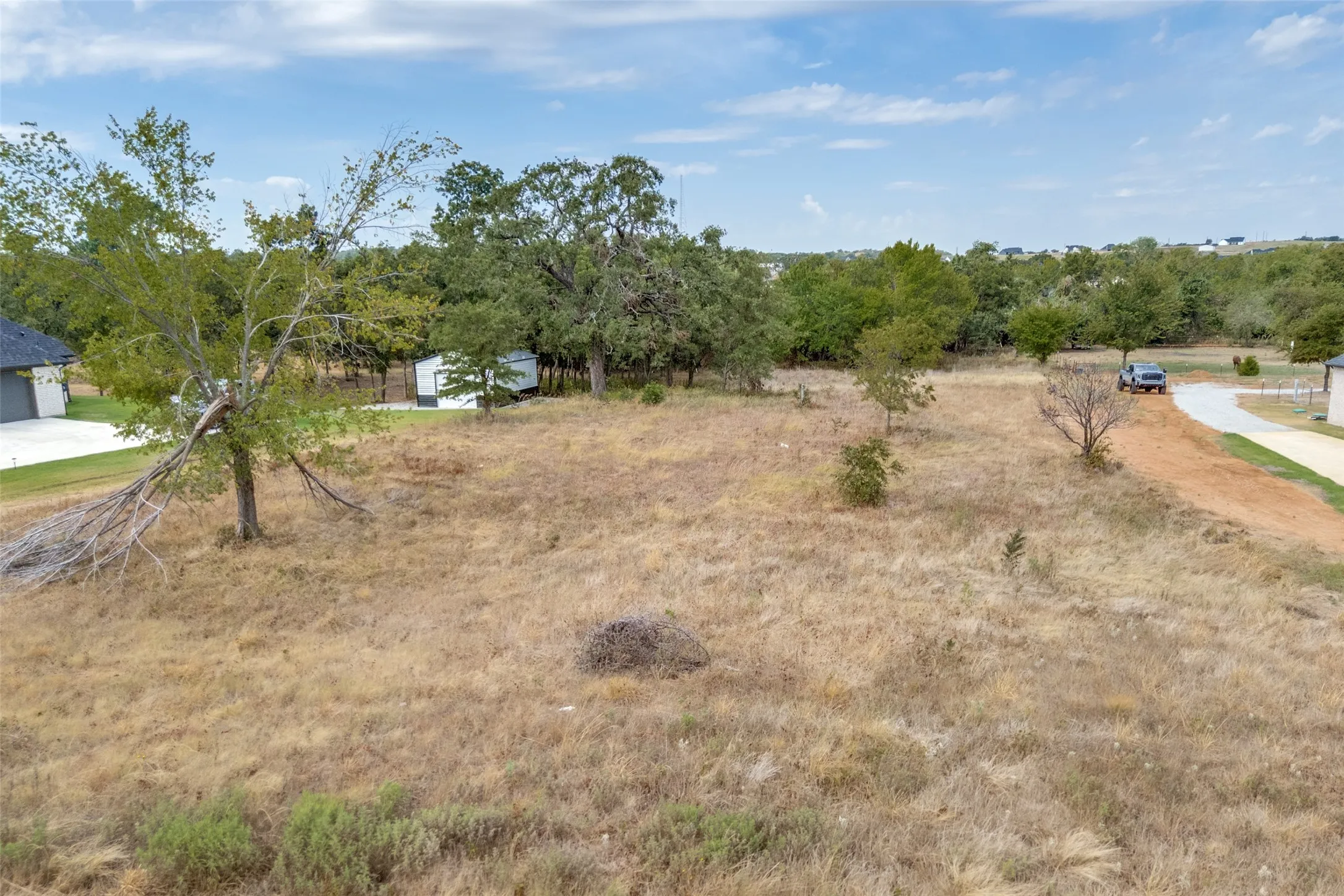 Expansive undeveloped lot with natural ground cover and scattered trees