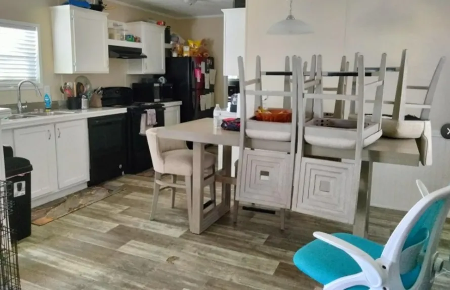 Wood-finish flooring, white cabinetry, integrated sink, and black appliances