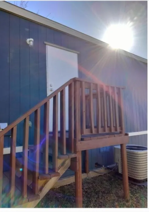 Wood-finish outdoor stairs leading to an entry door
