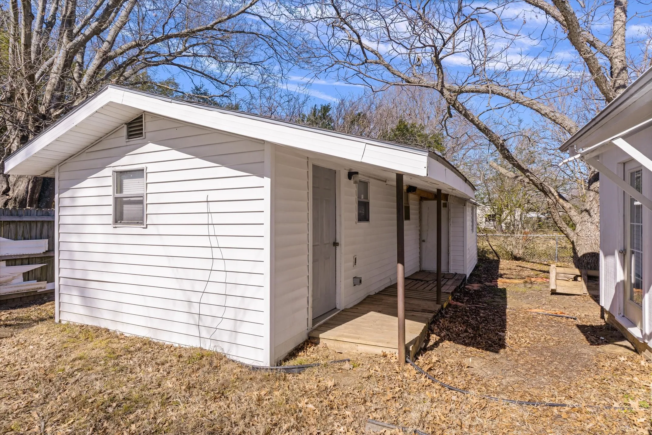 Charming cottage-style home featuring white horizontal siding, a covered front porch with wooden support posts, and a gabled roofline