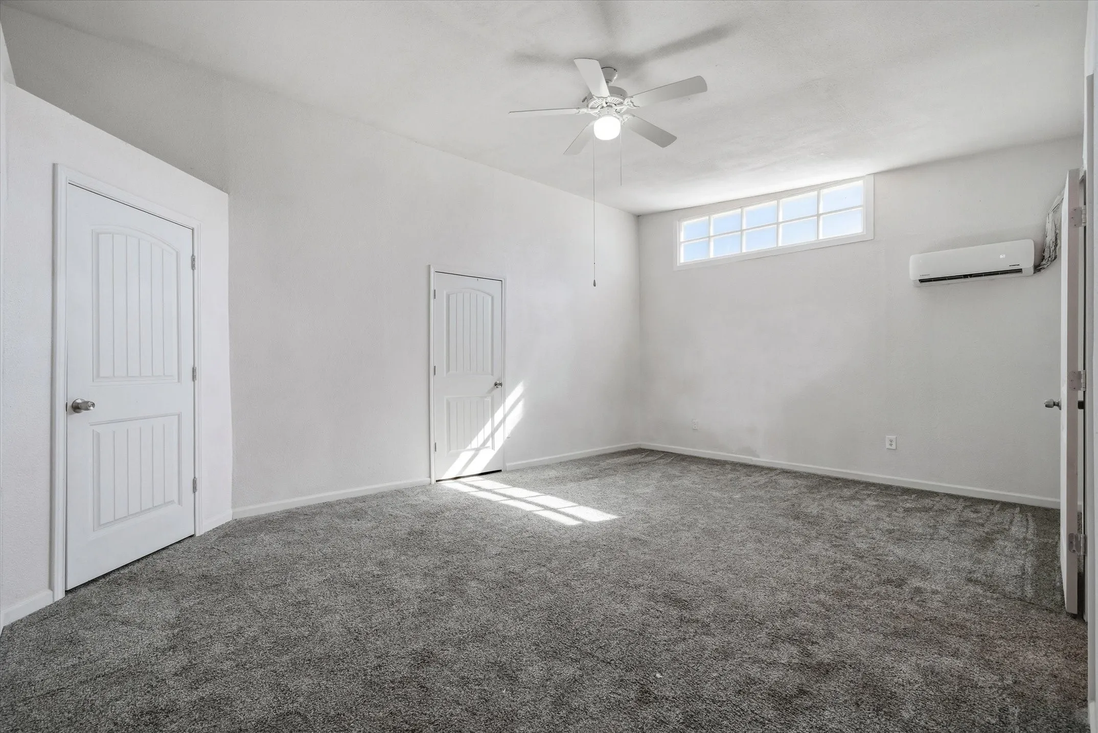 Recessed windows, ceiling fan, carpet flooring, and a wall-mounted climate control unit