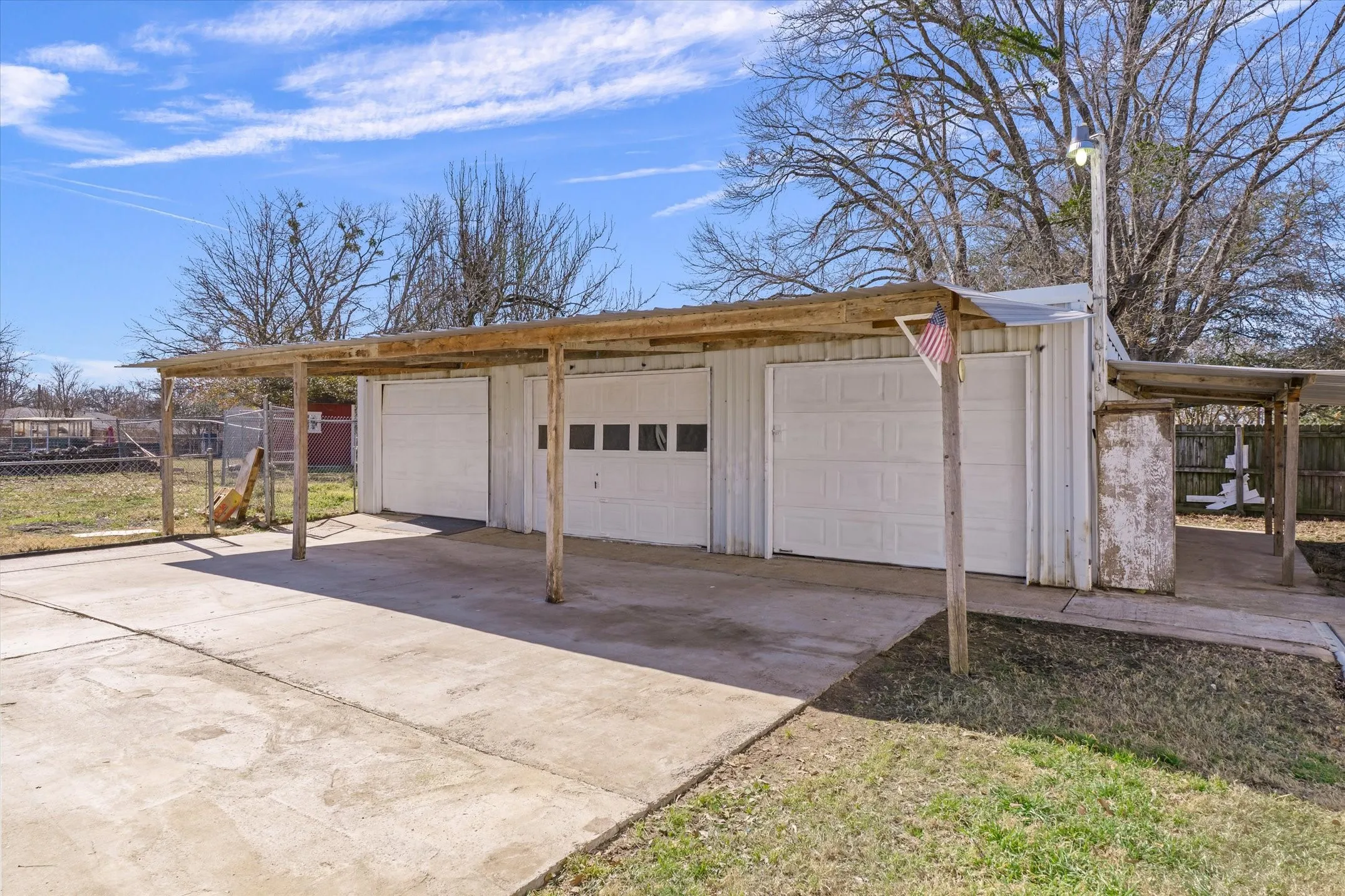 Attached three-car garage with overhead doors and an extended carport