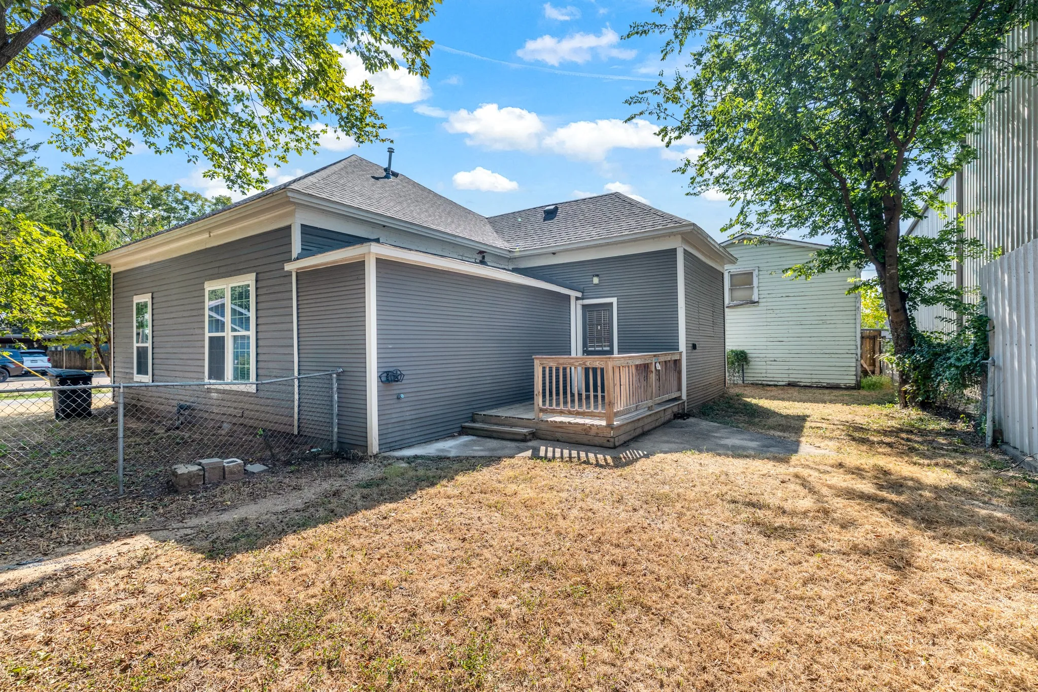 Exterior featuring gray horizontal siding, white window trim, and a private wood-finish deck with railings