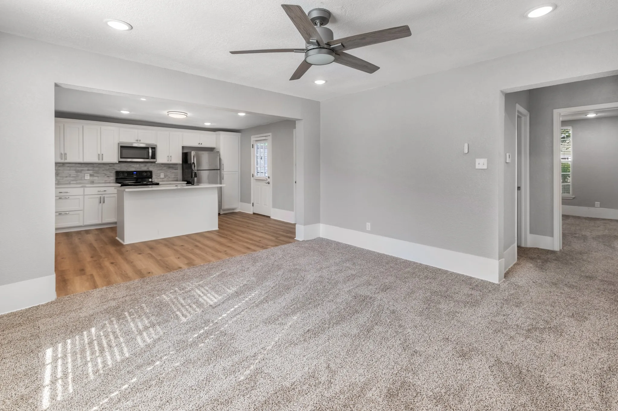 Kitchen with white cabinetry, stainless steel appliances, and a central island