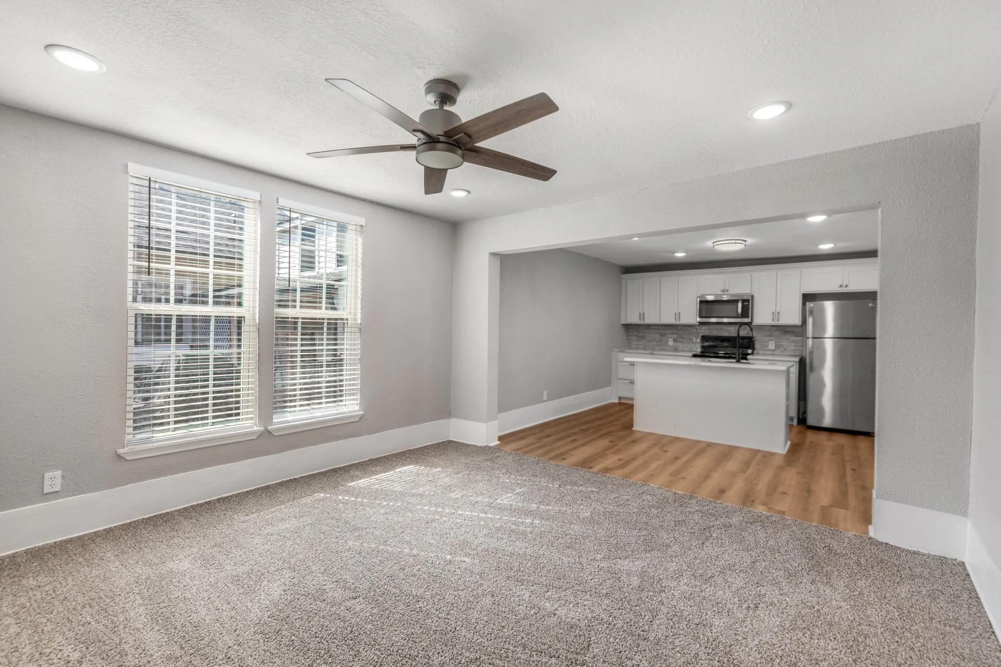 Open concept living space featuring recessed lighting, a ceiling fan, and carpeted flooring