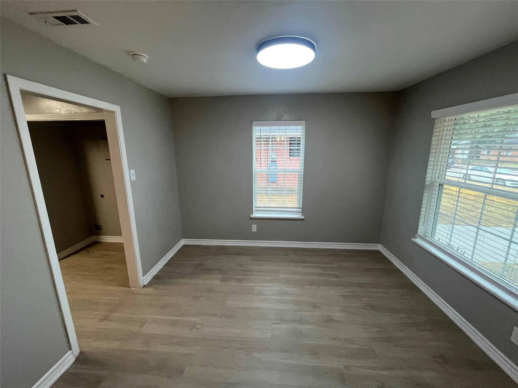 Recessed lighting, wood-finish flooring, white trim, and window blinds