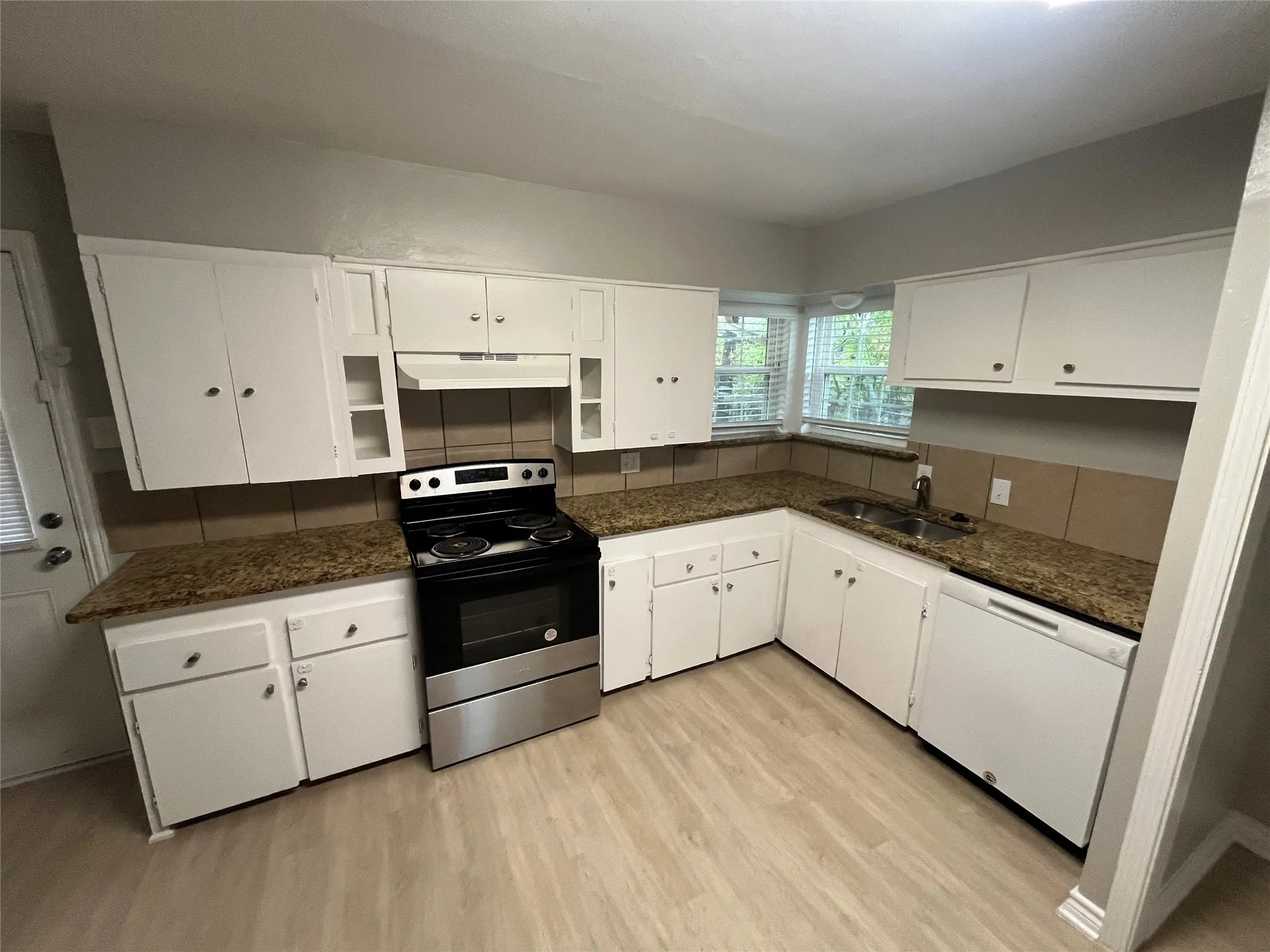 Kitchen featuring white cabinetry, wood-finish flooring, and light brown countertops