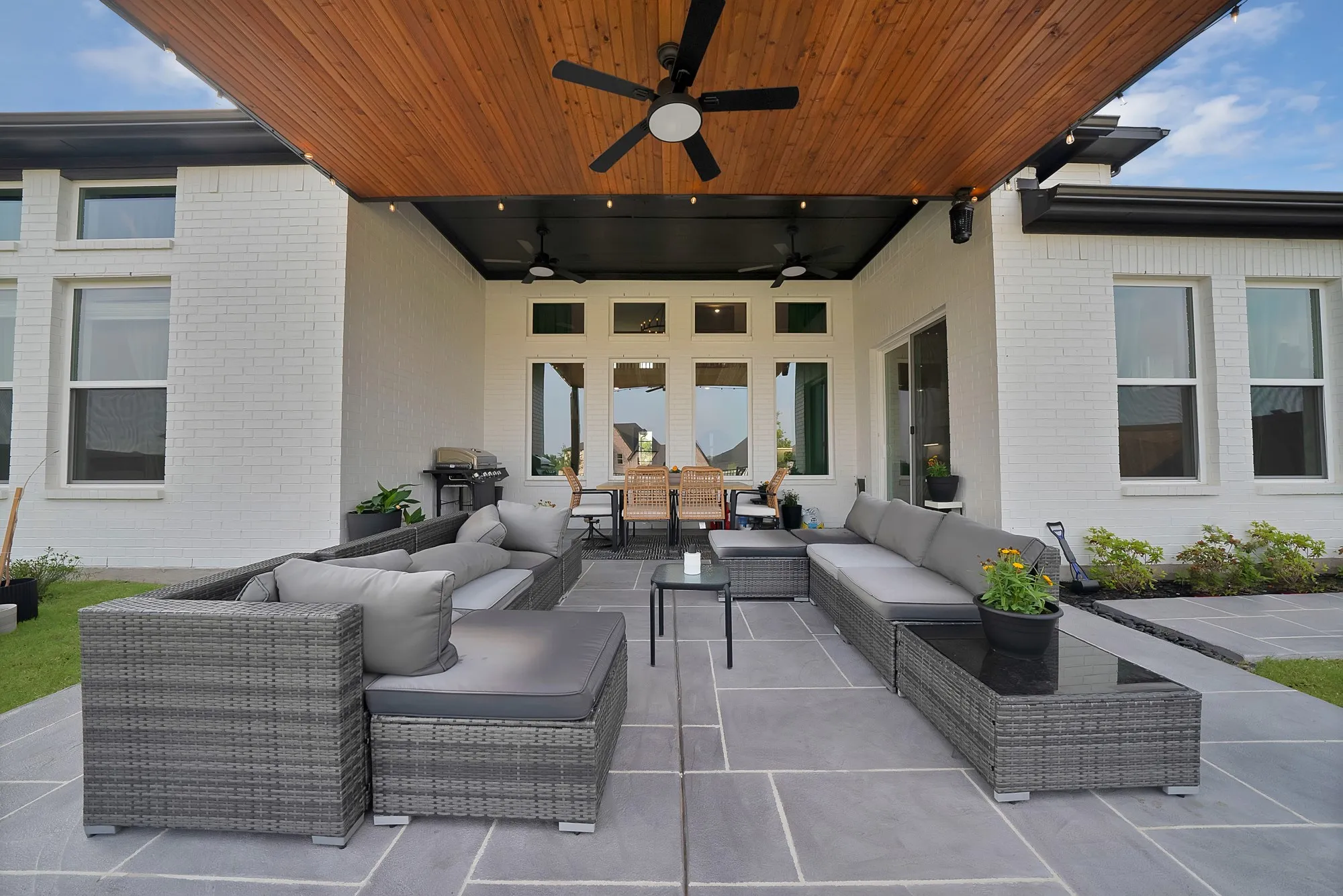 Expansive covered patio featuring a wood-panel ceiling, built-in ceiling fans, and recessed lighting