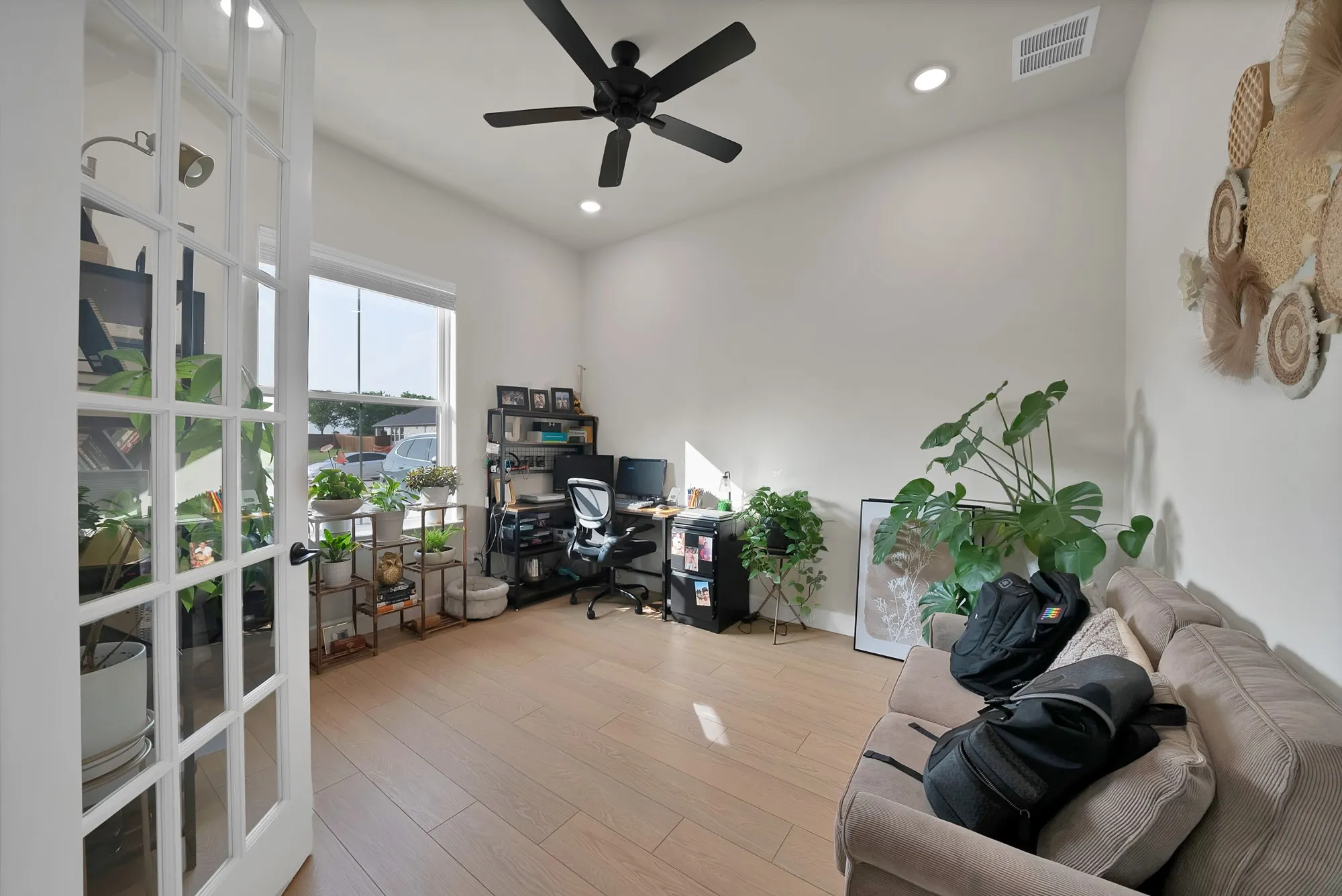 French doors with glass panels, wood-finish flooring, a ceiling fan, recessed lighting, and a wide window