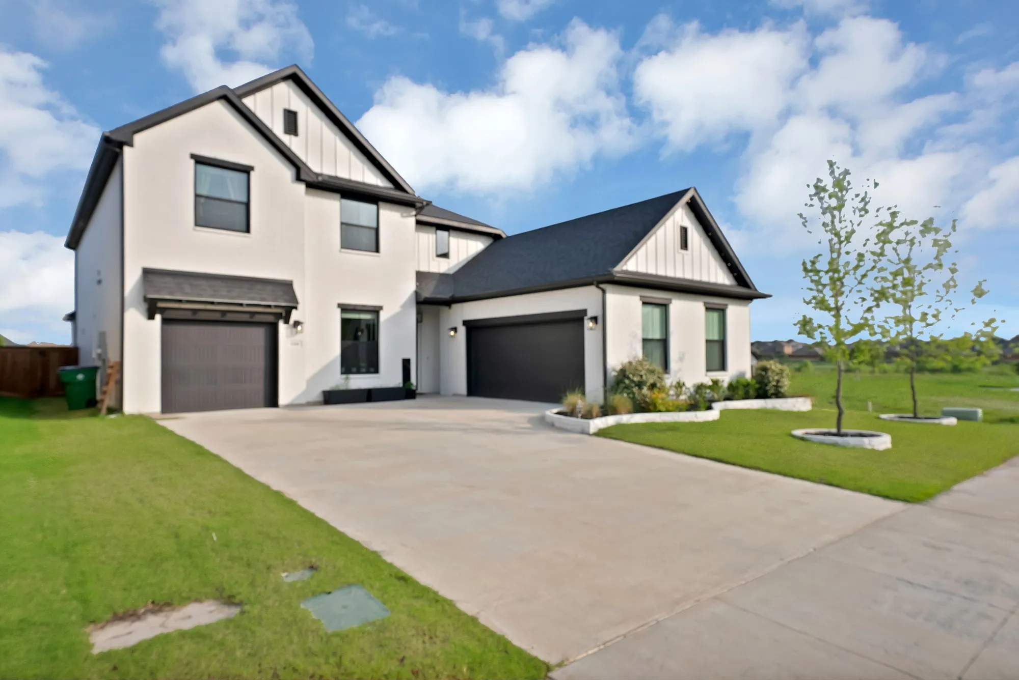 Modern two-story exterior with white stucco finish and dark trim accents