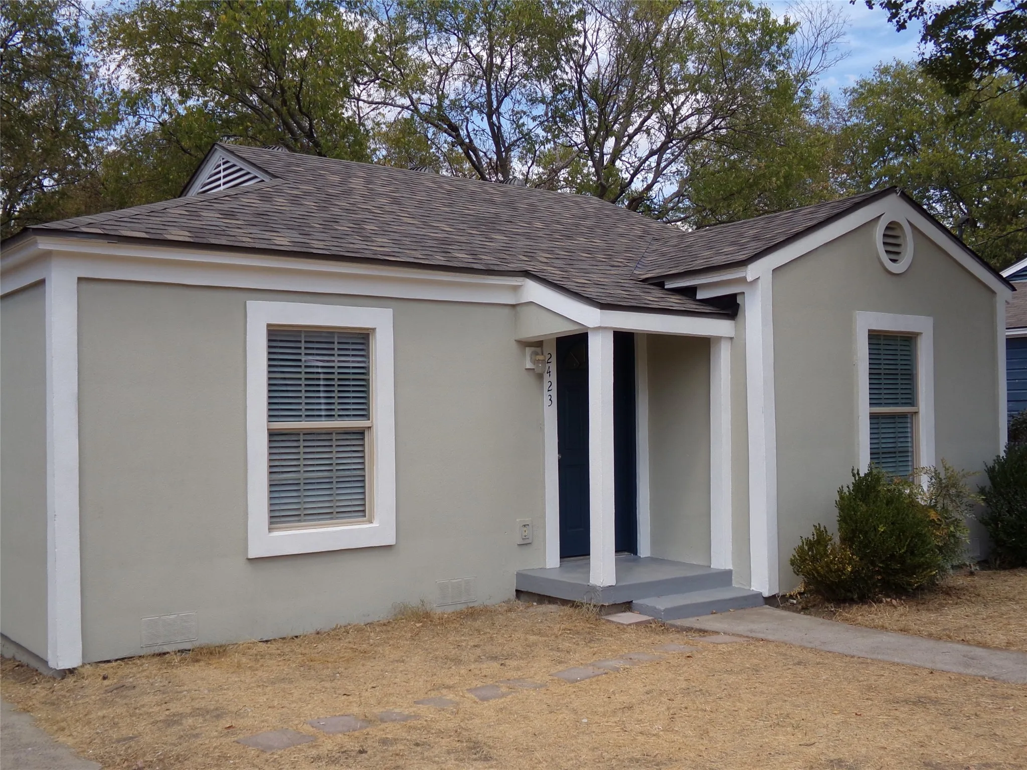 Light-colored exterior finish with white trim