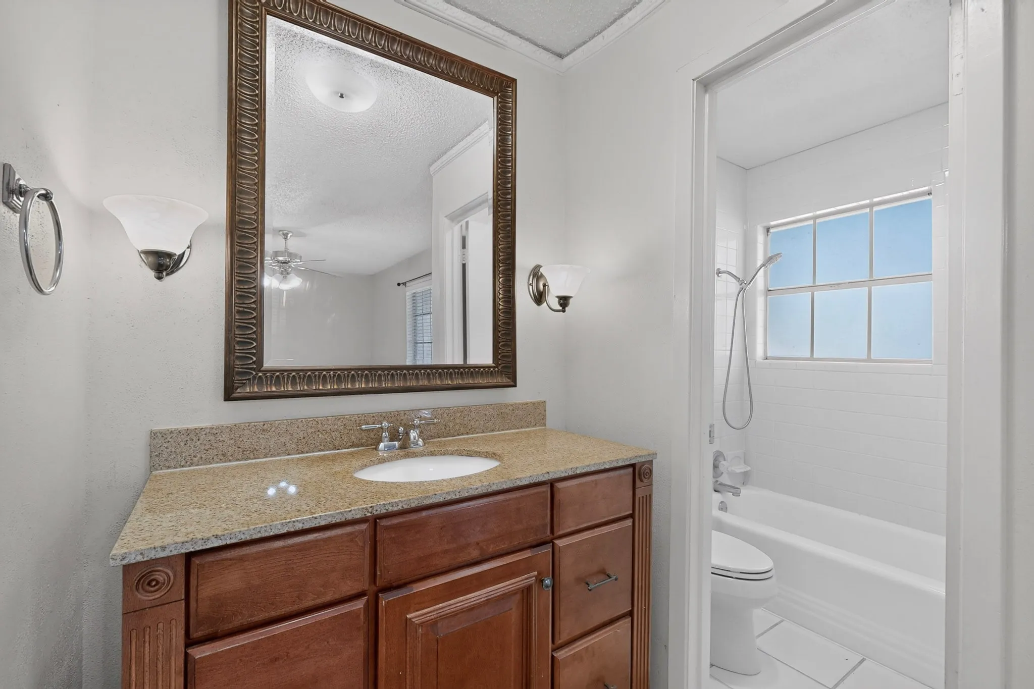 Wood-finish vanity with an integrated sink and light-toned countertop