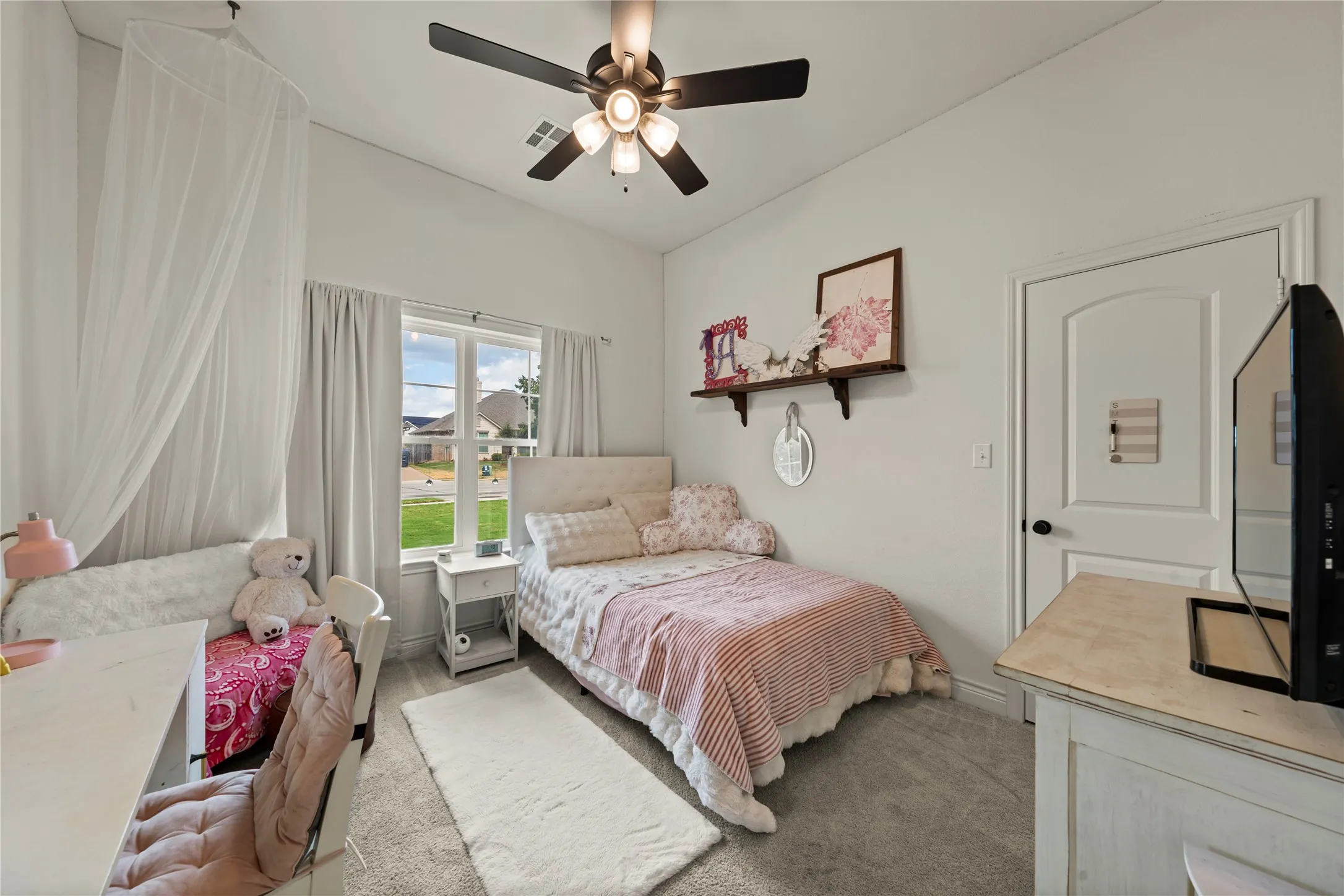 White painted walls, arched interior door, ceiling fan with light kit, and a double-pane window