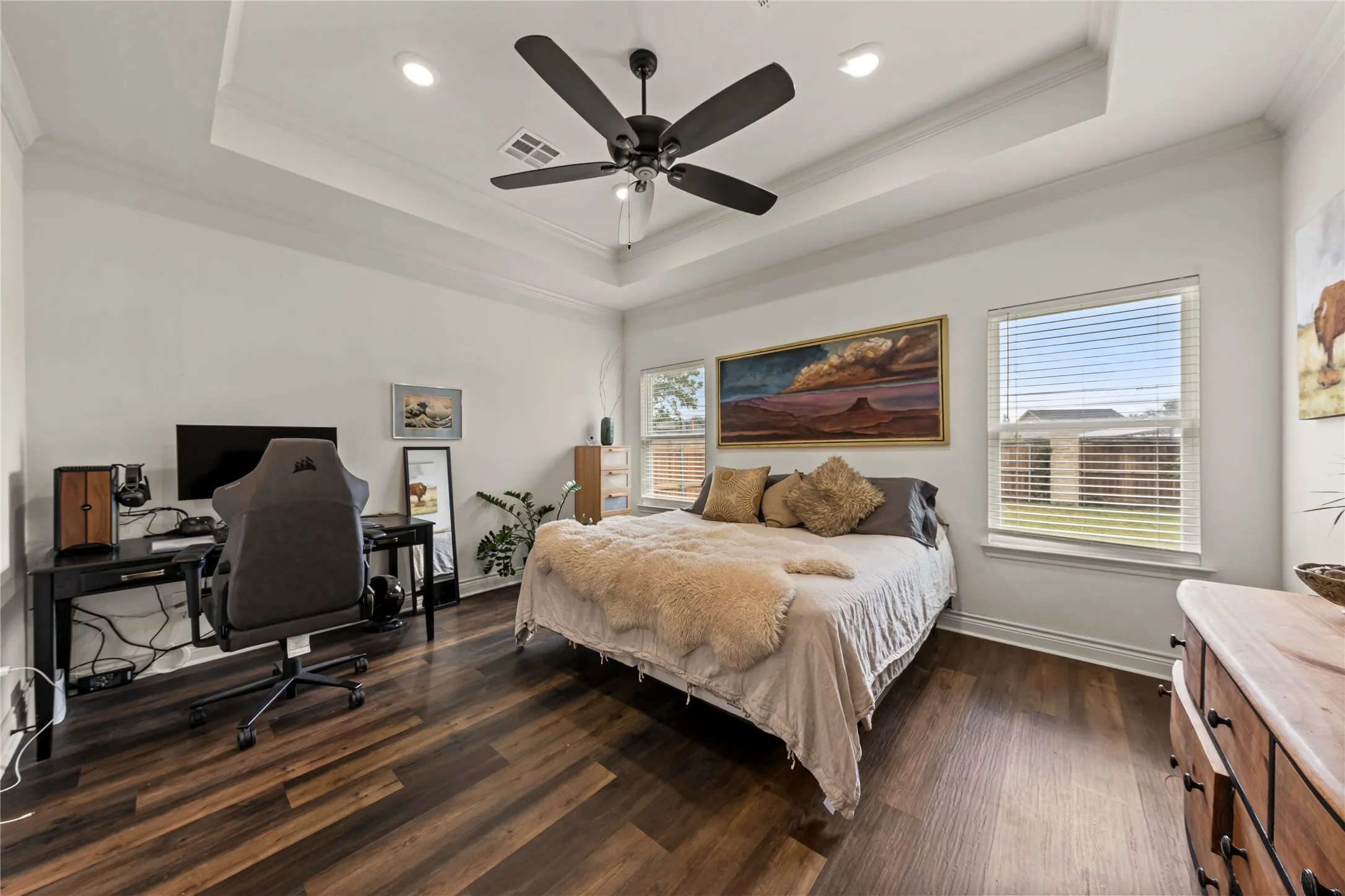Tray ceiling with recessed lighting and a ceiling fan, wood-finish flooring, and multiple windows